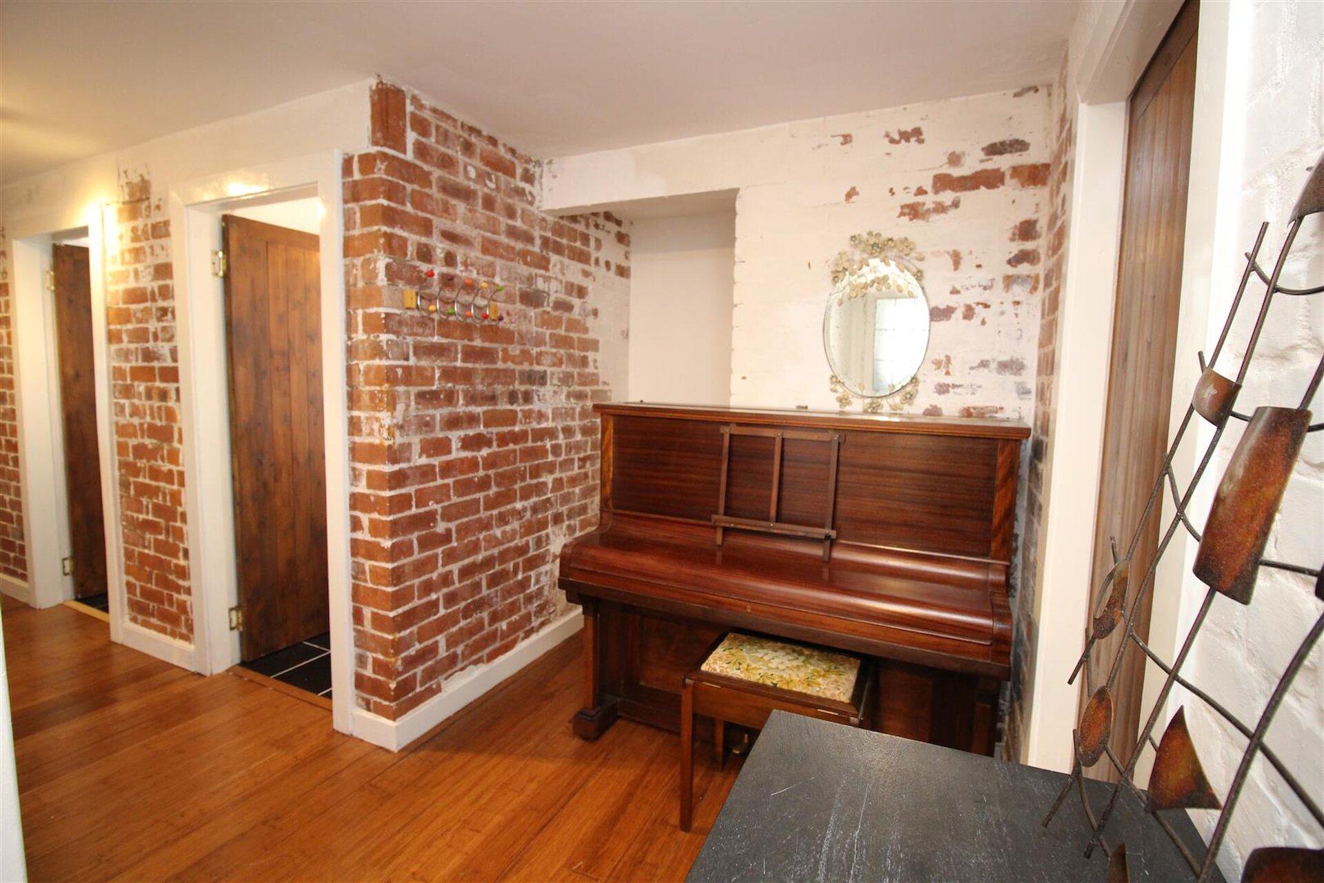 Exposed brick walls line the main hallway, leading into the lounge and bedrooms. 