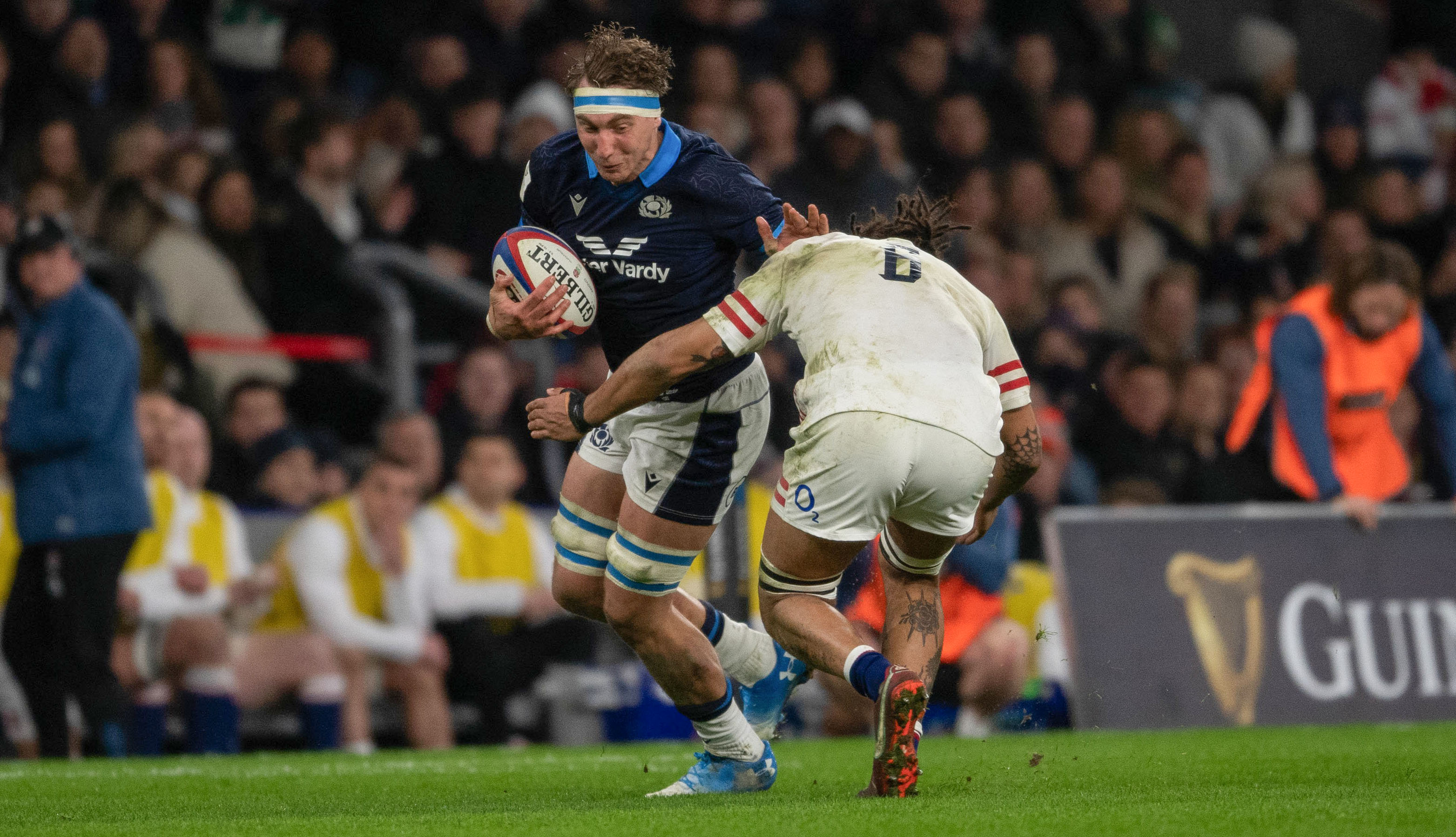 Scotland's Jamie Ritchie is tackled by England's Lewis Ludlam.