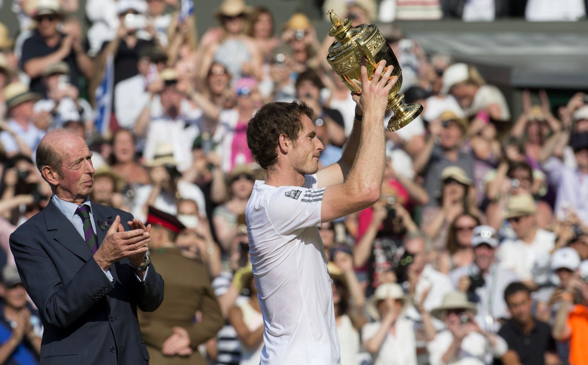 The Duke of Kent (left) looks on as Andy Murray lifts the Wimbledon trophy.