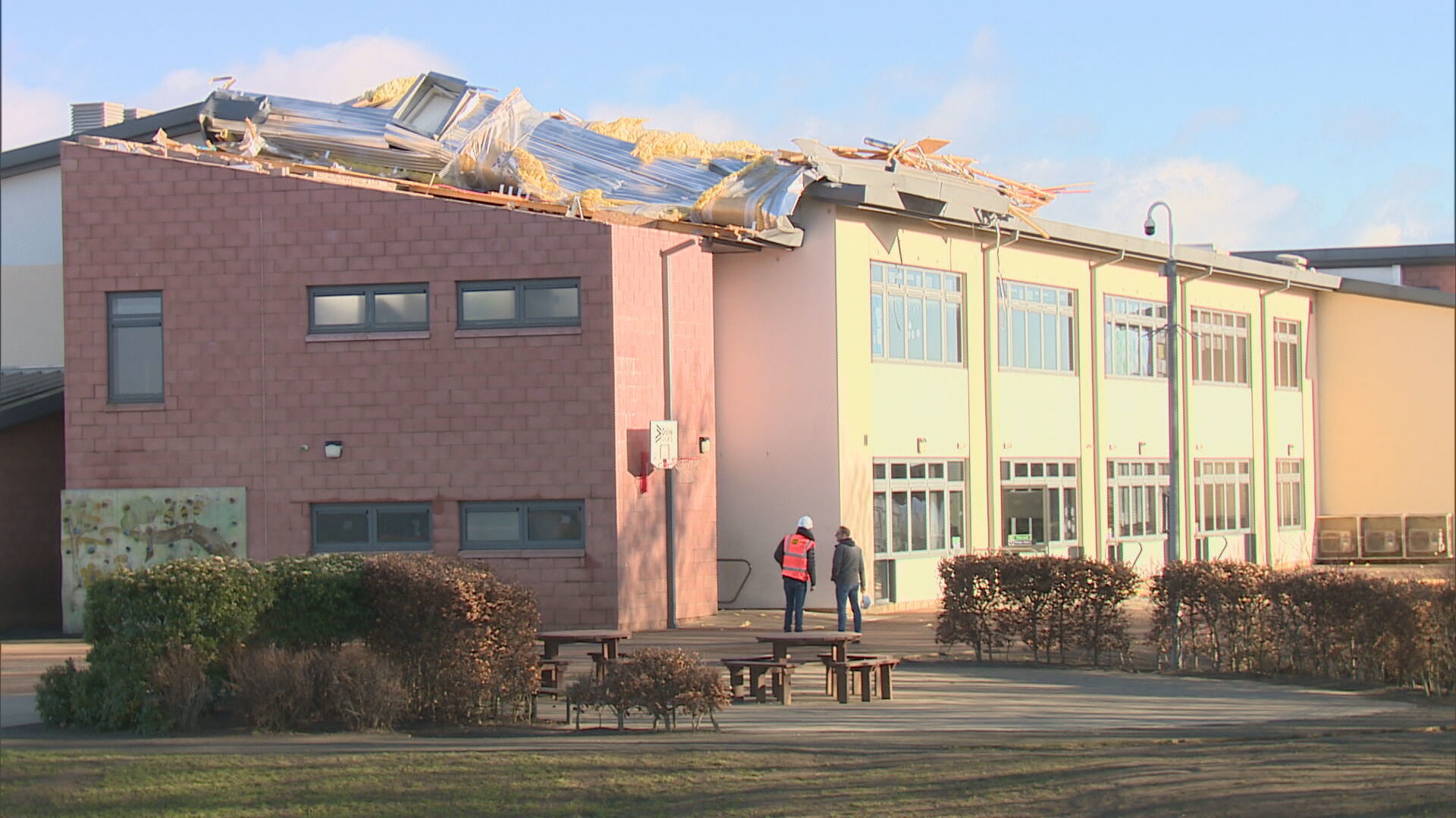 Roof of a building is seen partially torn off by strong winds.