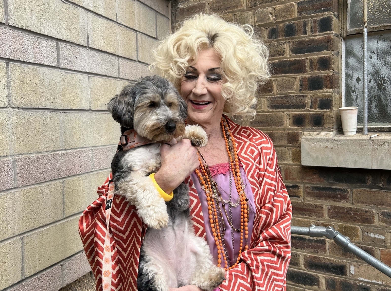 O'Grady dressed as Miss Hannigan, the main antagonist in Annie, cuddling a dog in Edinburgh. 