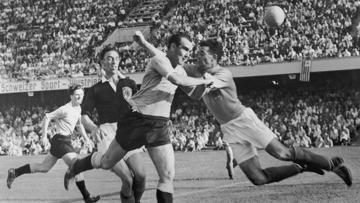 Scottish goalkeeper Fred Martin (centre) rushes out as Uruguayan centre-forward Oscar Miguez during Scotland's 7-0 defeat.