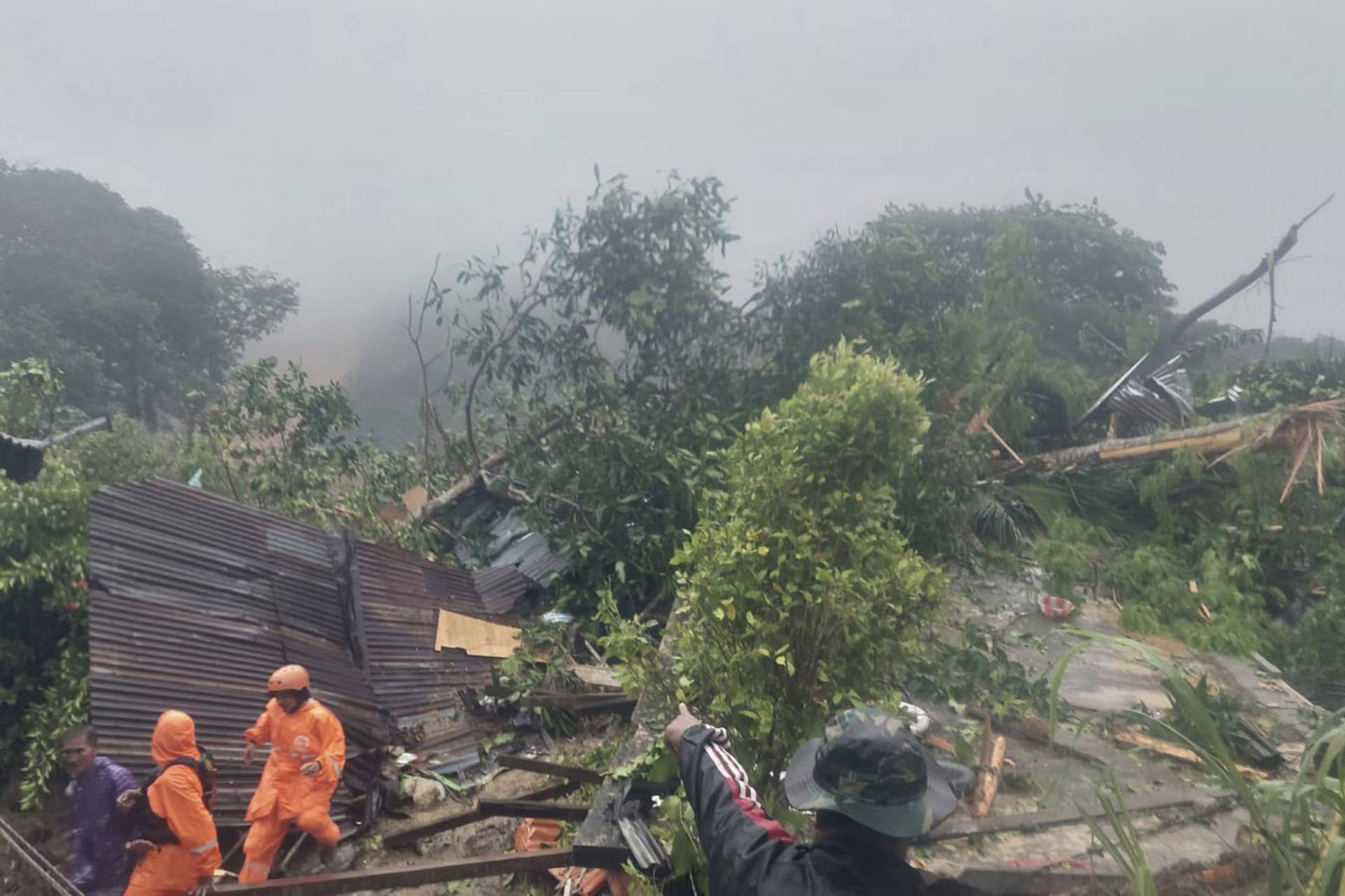Rrescuers search for victims at the site where a landslide hit a village on Serasan Island, Natuna regency.
