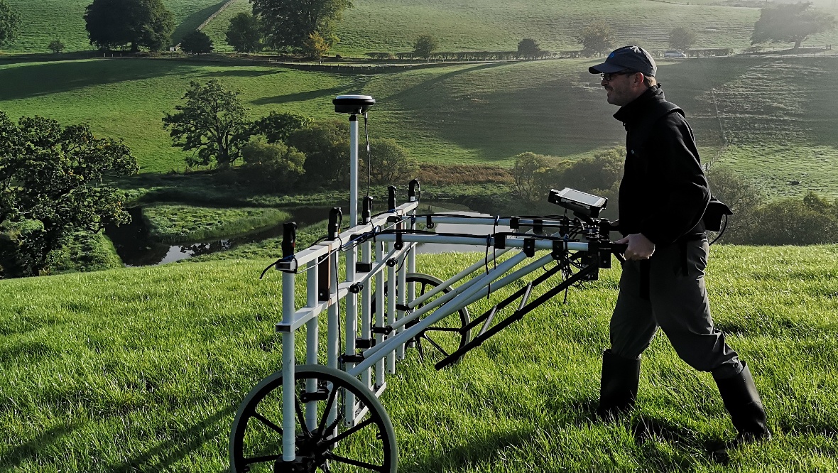 An archaeologist using gradiometry to discover the fortlet. 