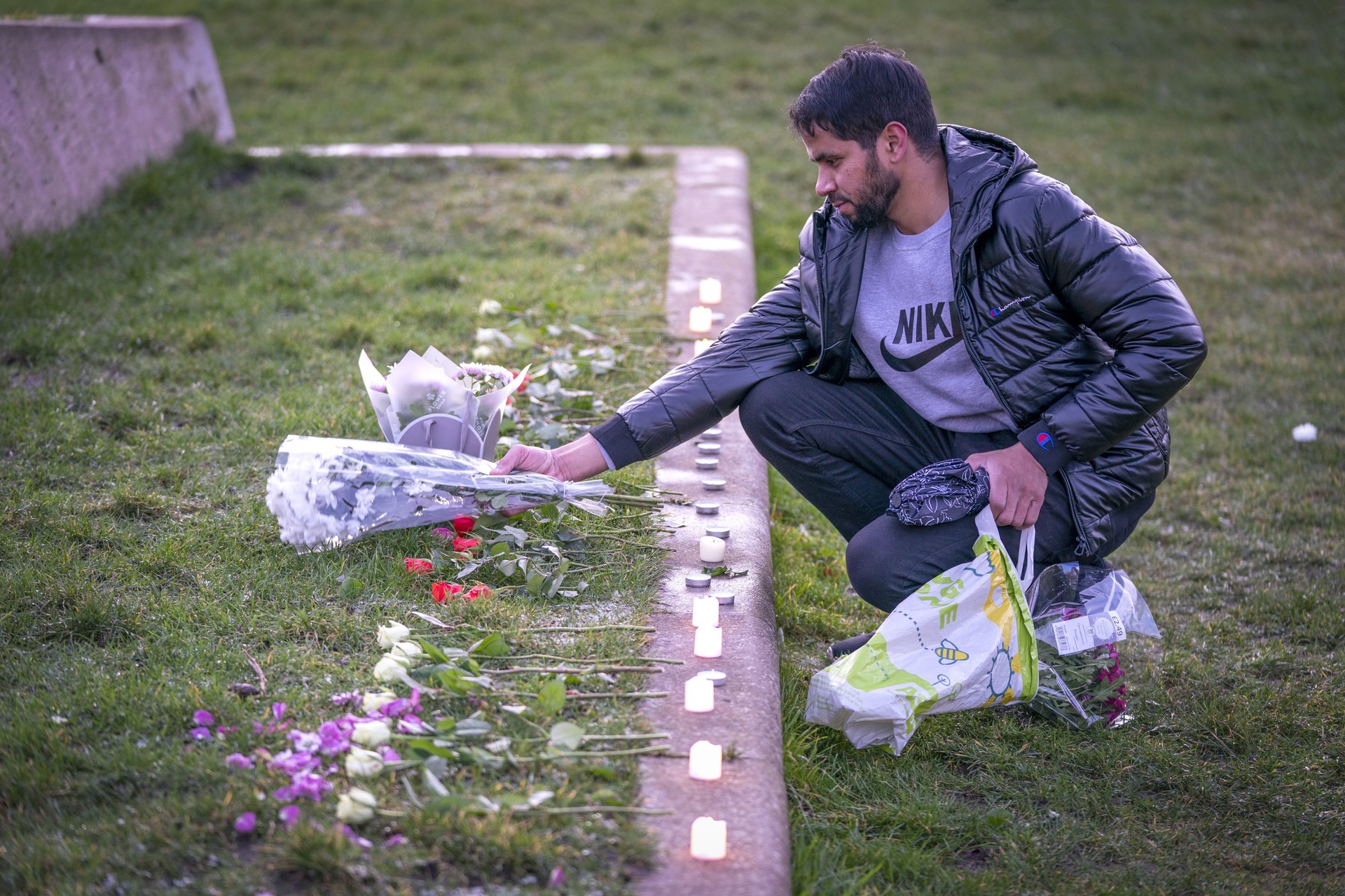 Adnan Hanif, uncle of Fawziyah Javed, lays flowers during a vigil held in honour of Fawziyah who died on Arthur’s Seat.<br>” /><span class=