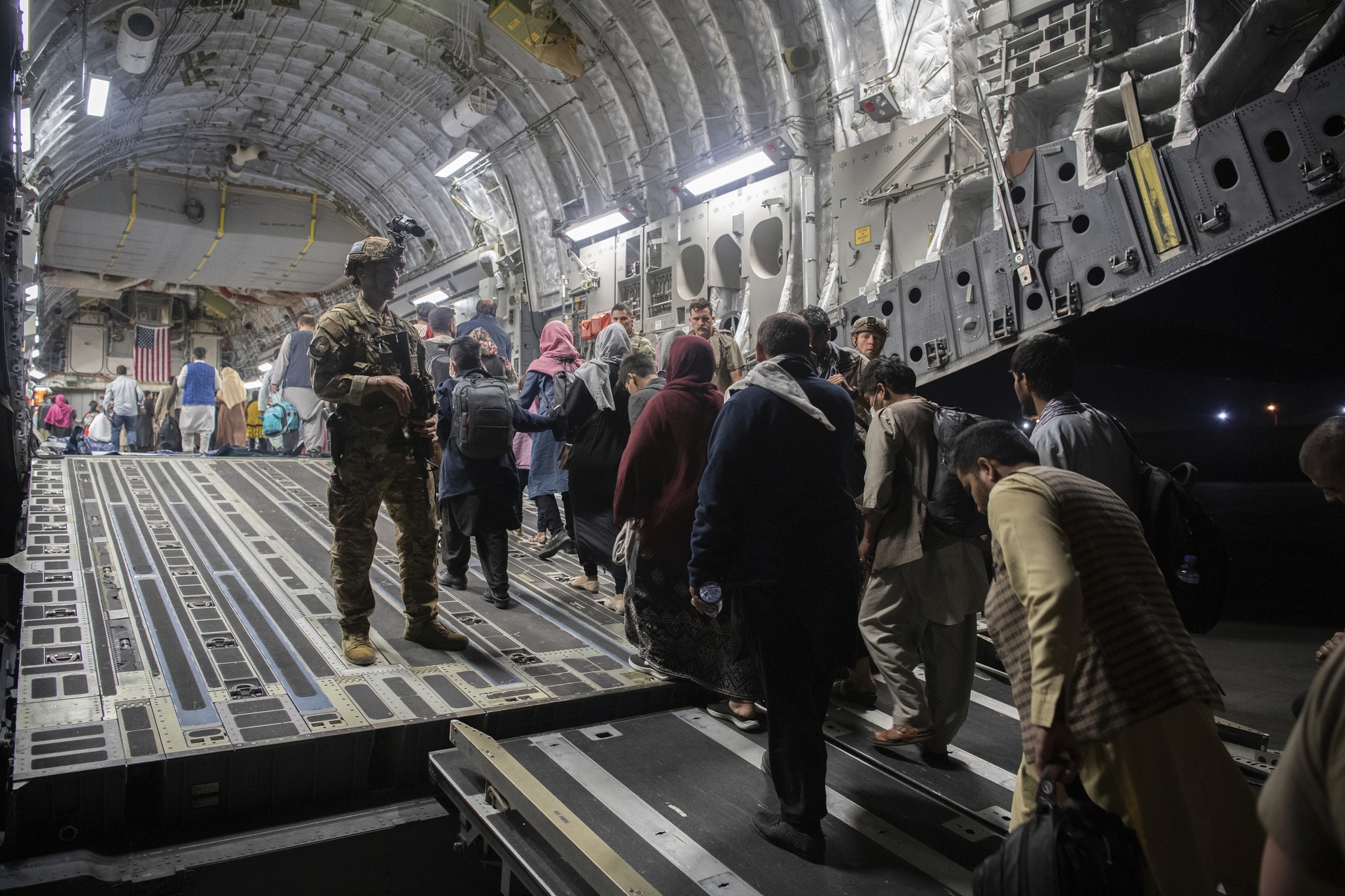 Afghan passengers board a U.S. Air Force C-17 Globemaster III during the Afghanistan evacuation at Hamid Karzai International Airport in Kabul.