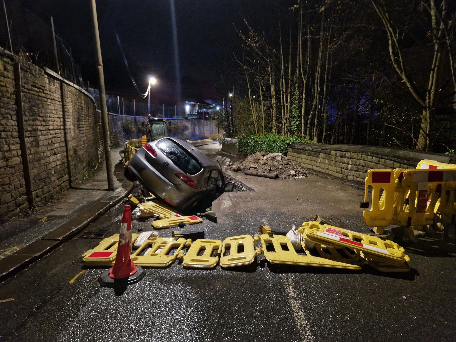 Police were called to Dale Street in Huddersfield at 11.23pm on Tuesday to a report a car had crashed where they found the vehicle stuck in the ground.