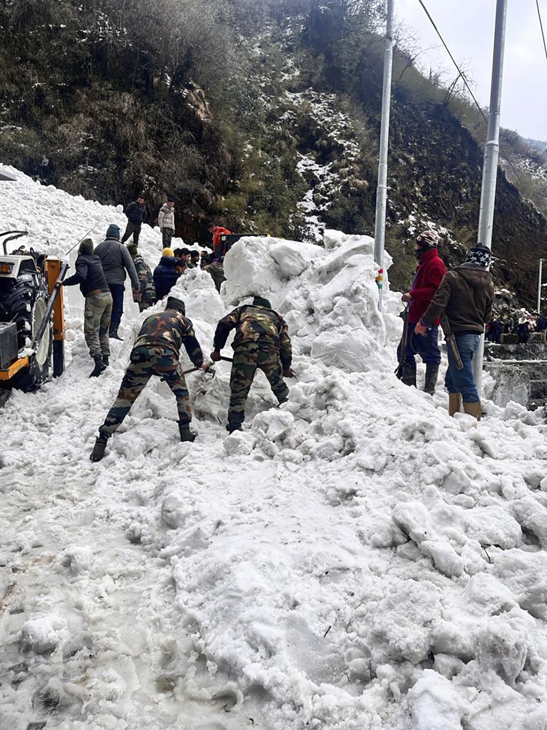 Soldiers clear snow from an avalanche near Nathu La mountain pass in India's Sikkim state (Indian Army via AP)