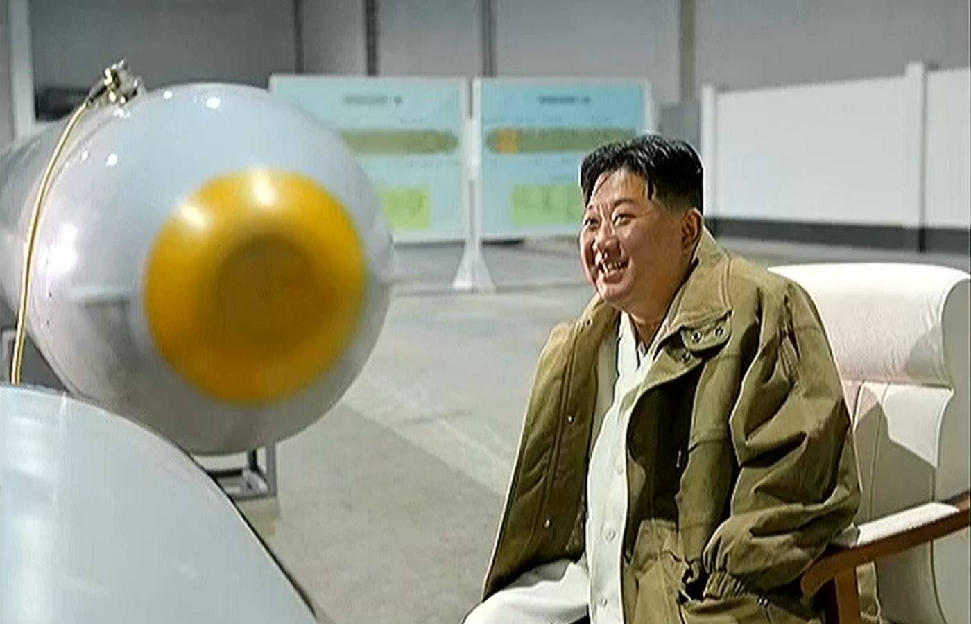 North Korea’s official Rodong Sinmun newspaper published photographs of Kim smiling next to a large torpedo-shaped object .