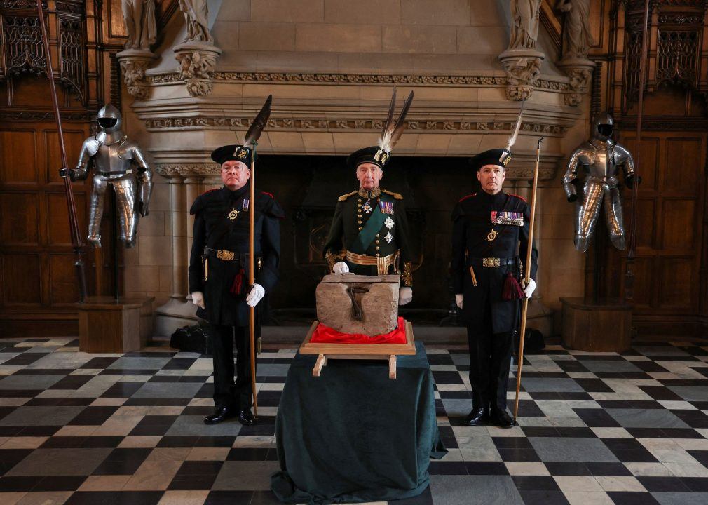 The Duke of Buccleuch, flanked by two Officers of Arms, stands beside the Stone of Destiny