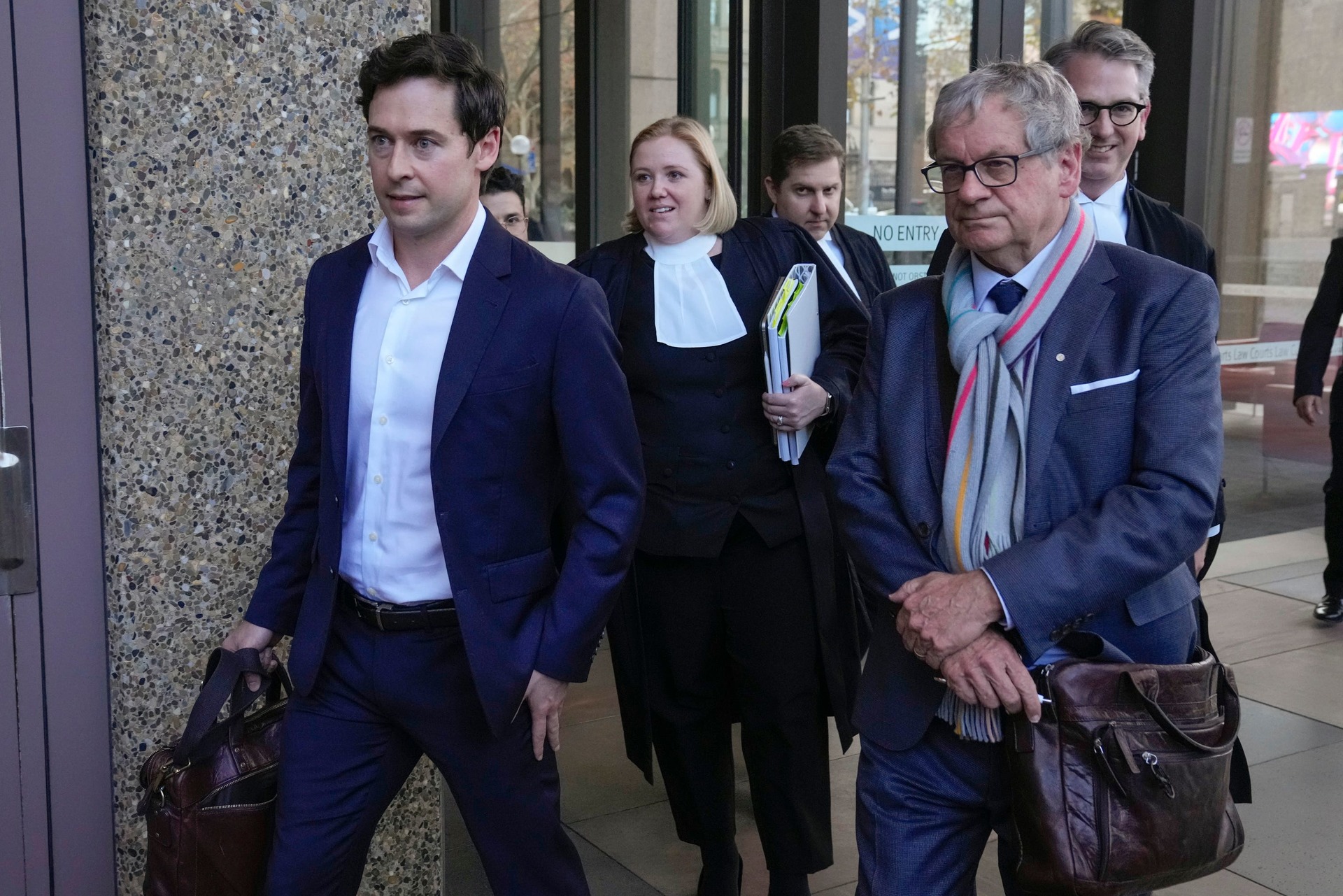 Australian journalists Nick McKenzie (left) and Chris Masters (right) walk with their legal team (Mark Baker/AP) 