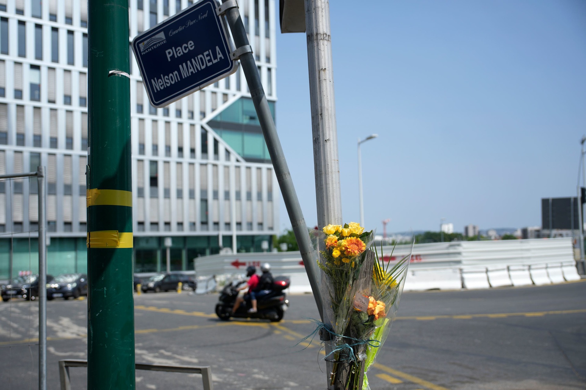 Flowers are attached to a pole where a young man was killed by a police office in Nanterre.