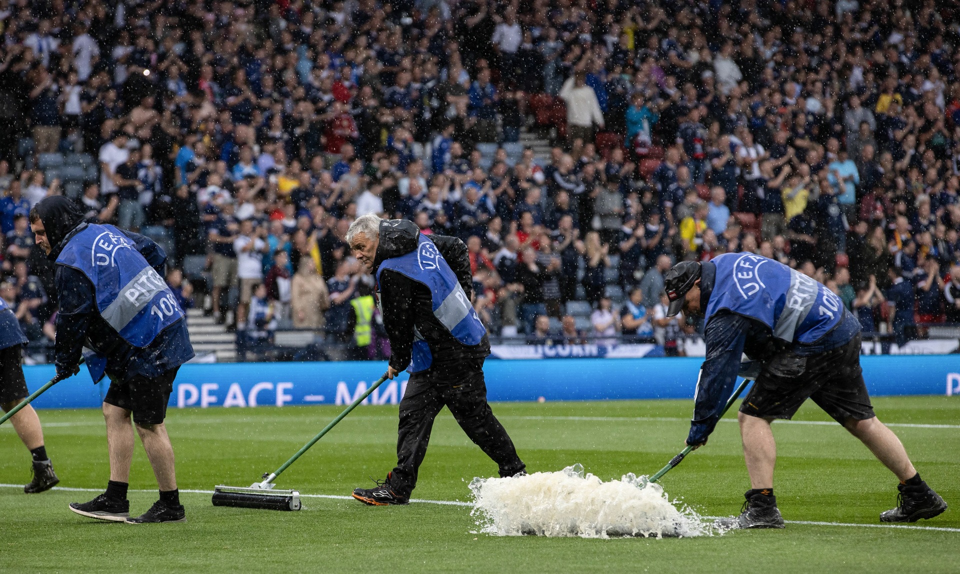 GLASGOW, SCOTLAND - JUNE 20: Pitch staff try to clear the water off the park during a UEFA Euro 2024 qualifier between Scotland and Georgia at Hampden Park, on June 20, 2023, in Glasgow, Scotland. (Photo by Alan Harvey / SNS Group)