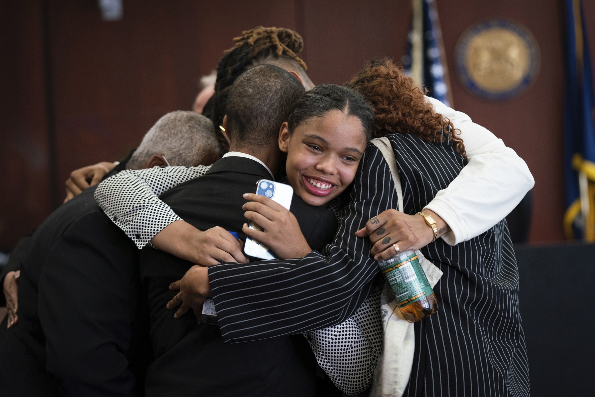 Aretha Franklin's granddaughter Grace Franklin, 17, smiles while embracing her family members.