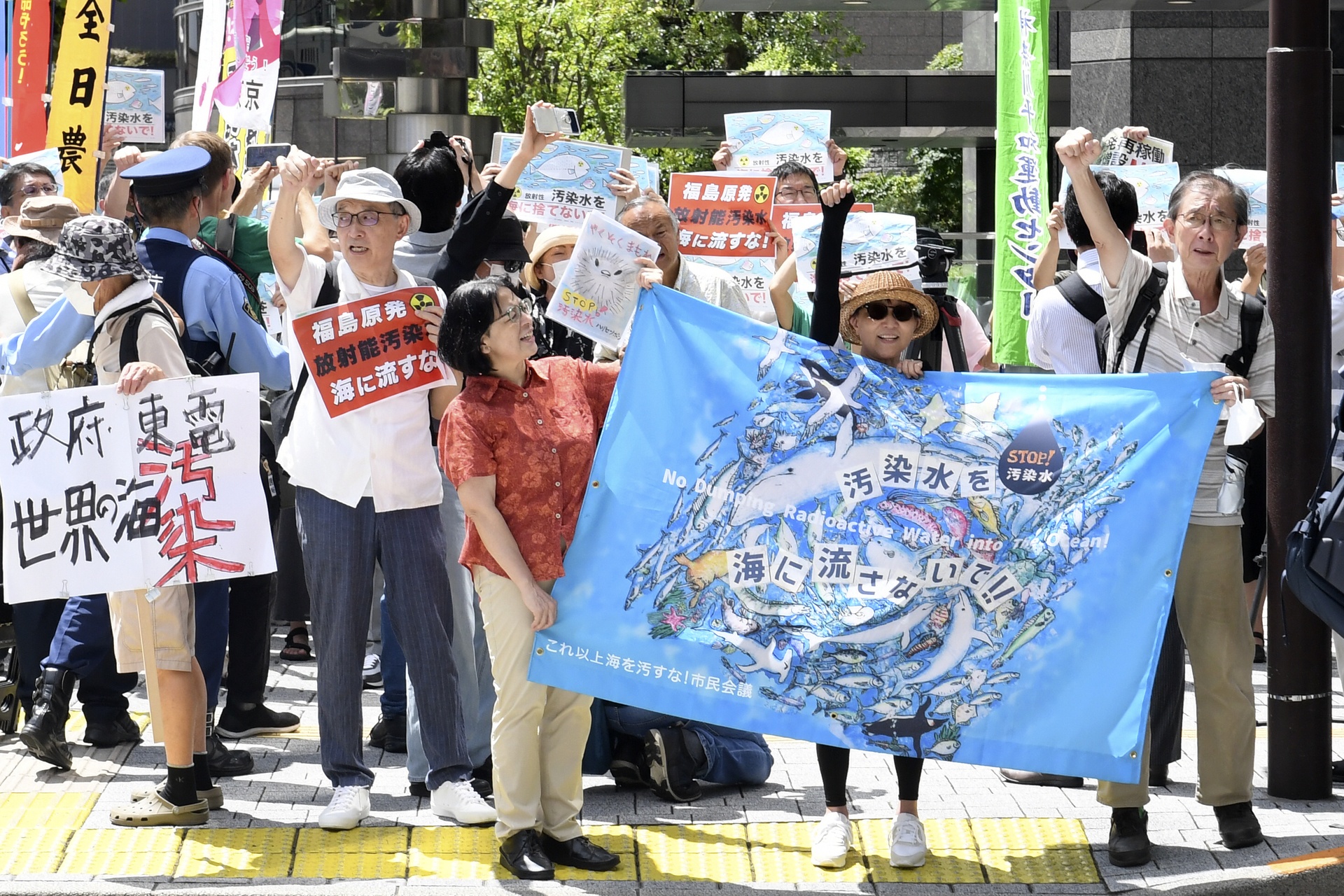 A protester holds a sign during a rally against the treated radioactive water release from the damaged Fukushima nuclear power plant, in front of TEPCO headquarters in Tokyo.