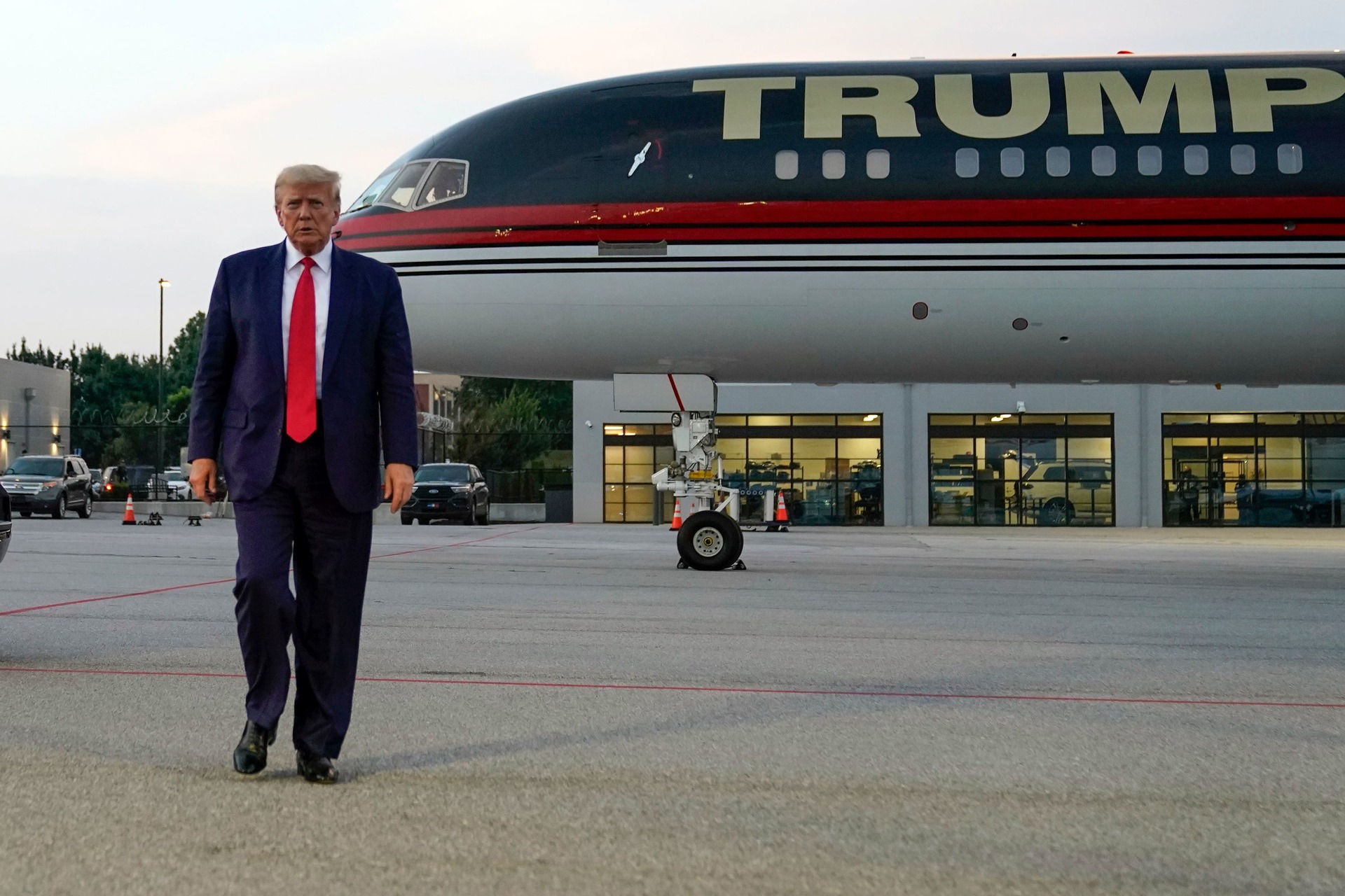 Former president Donald Trump walks over to speak with reporters before departure from Hartsfield-Jackson Atlanta International Airport.