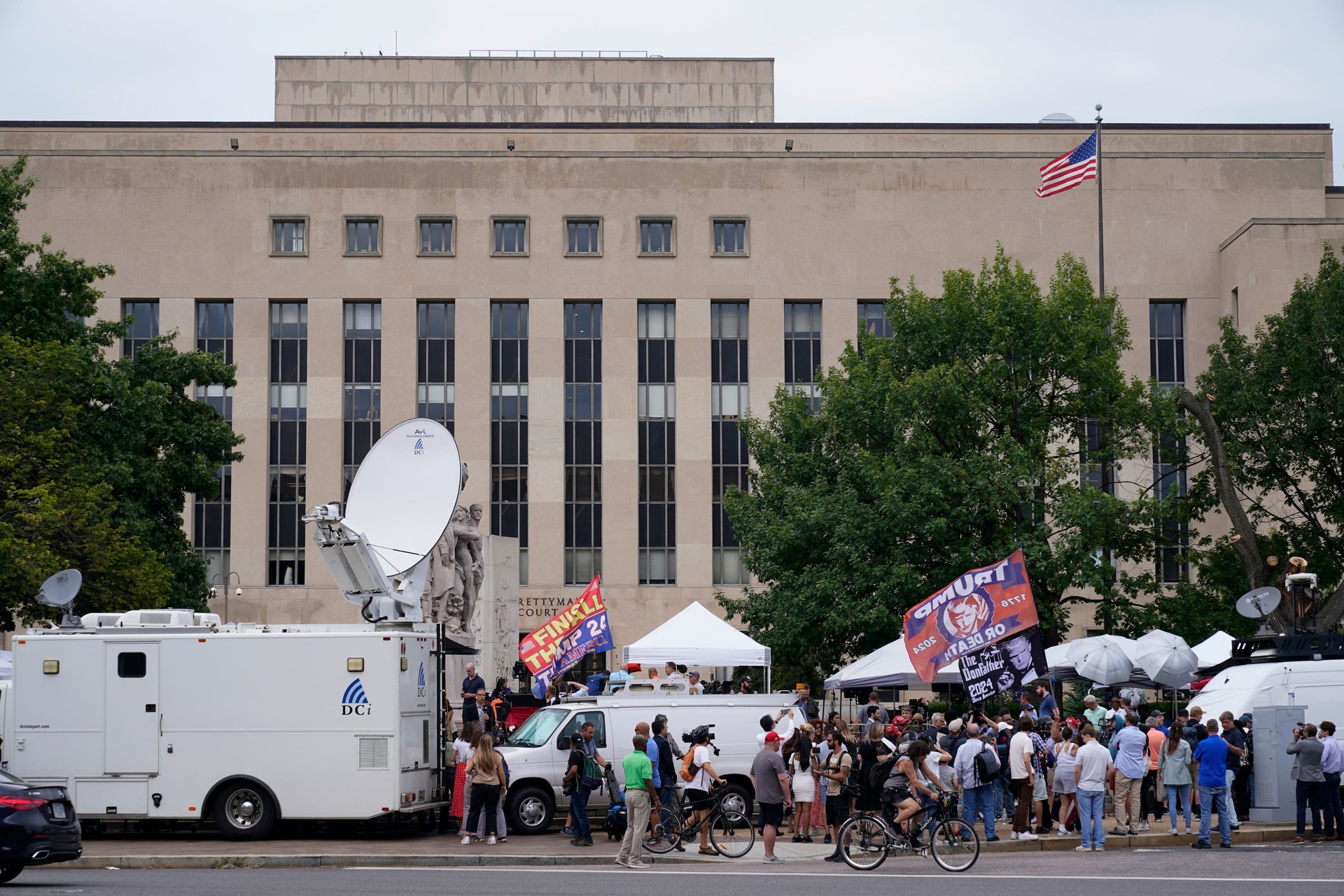Media and protesters gather at the E Barrett Prettyman US Federal Courthouse.