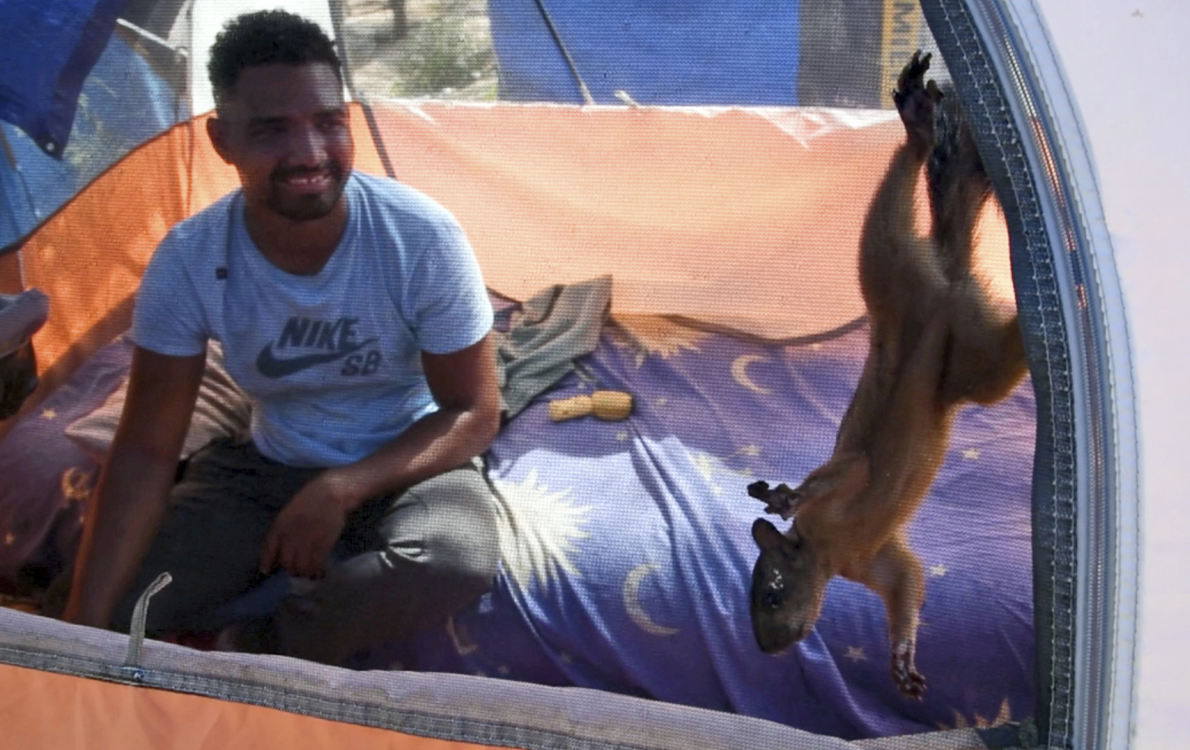 In this image taken from video, Niko, a pet squirrel, and his owner, Yeison, in their tent at a migrant camp, Wednesday, Sept. 20, 2023 in Matamoros, Mexico. Yeison, who declined to give his last name because he fears for his family’s safety in Venezuela, traveled with Niko thousands of miles to the border with the United States. But Yeison and Niko may be separated if he is granted entrance to the U.S. (AP Photo/Valerie Gonzalez)