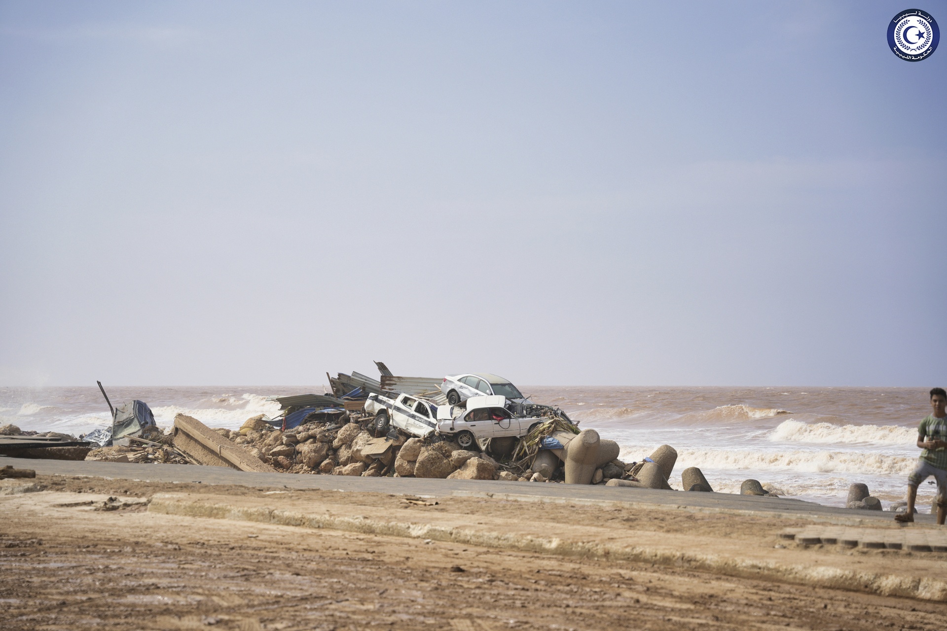 Cars sit piled on the sea bank in Derna.
