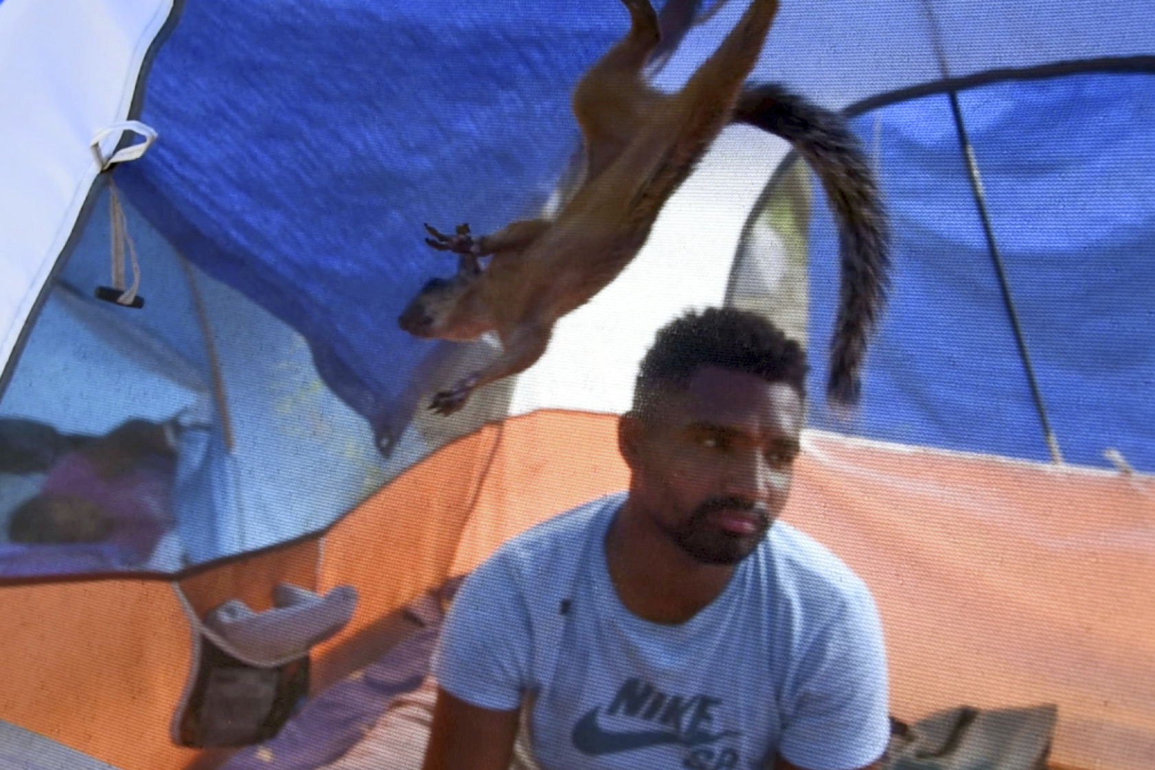 In this image taken from video, Niko, a pet squirrel, and his owner, Yeison, in their tent at a migrant camp, Wednesday, Sept. 20, 2023 in Matamoros, Mexico. Yeison, who declined to give his last name because he fears for his family’s safety in Venezuela, traveled with Niko thousands of miles to the border with the United States. But Yeison and Niko may be separated if he is granted entrance to the U.S. (AP Photo/Valerie Gonzalez)