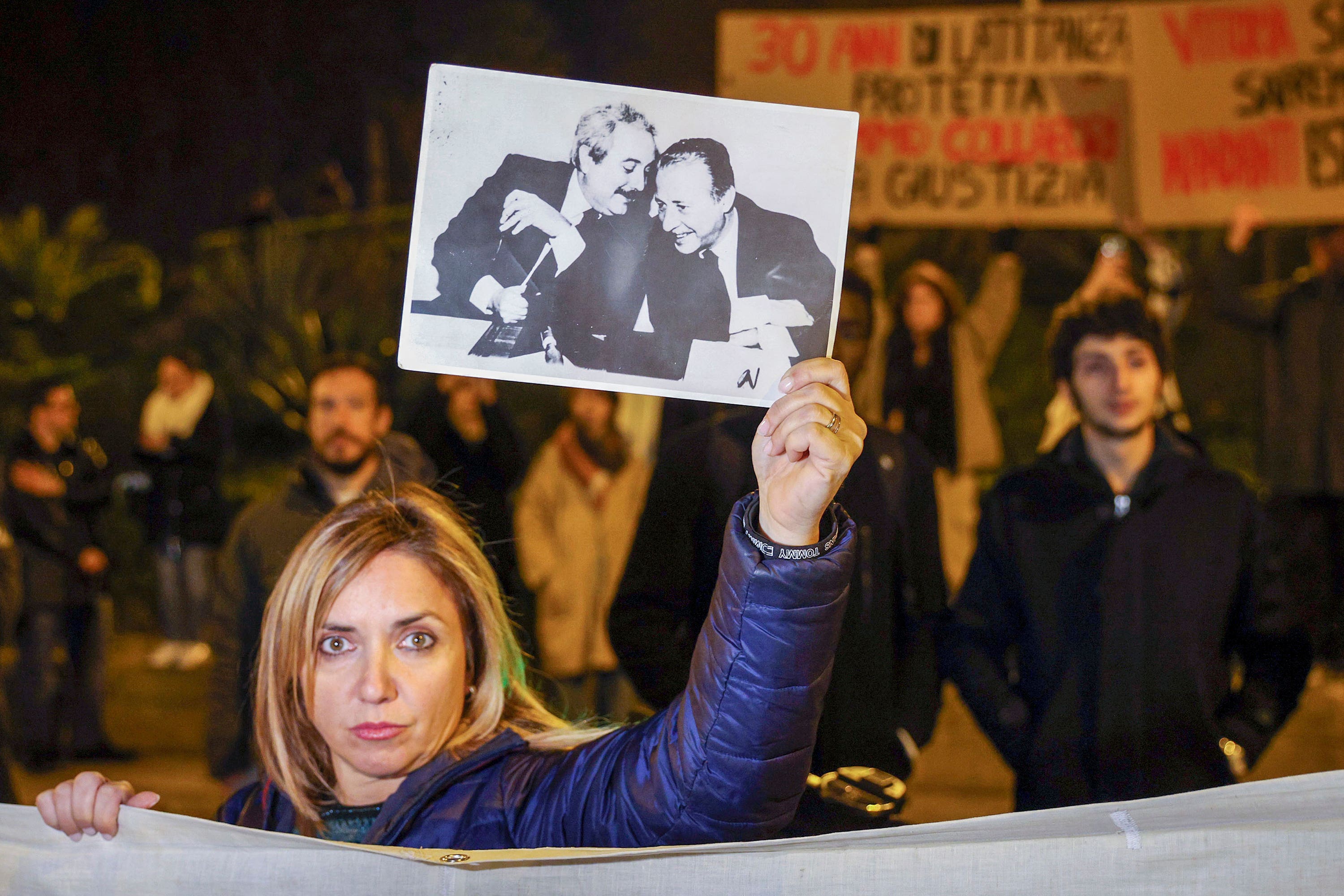 A woman displays a photograph showing top anti-mafia prosecutors Giovanni Falcone, left, and Paolo Borsellino (Alberto Lo Bianco/LaPresse/AP) 