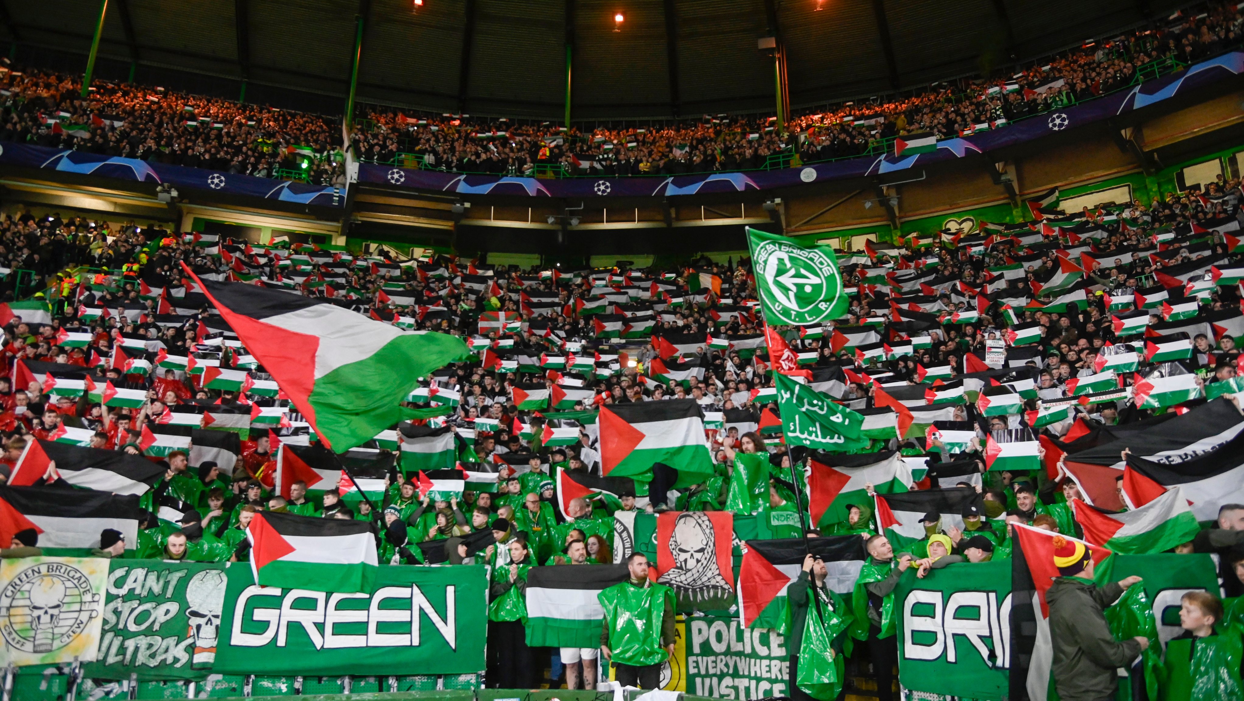 Green Brigade hold up Palestine flags during a UEFA Champions League match between Celtic and Atletico de Madrid.
