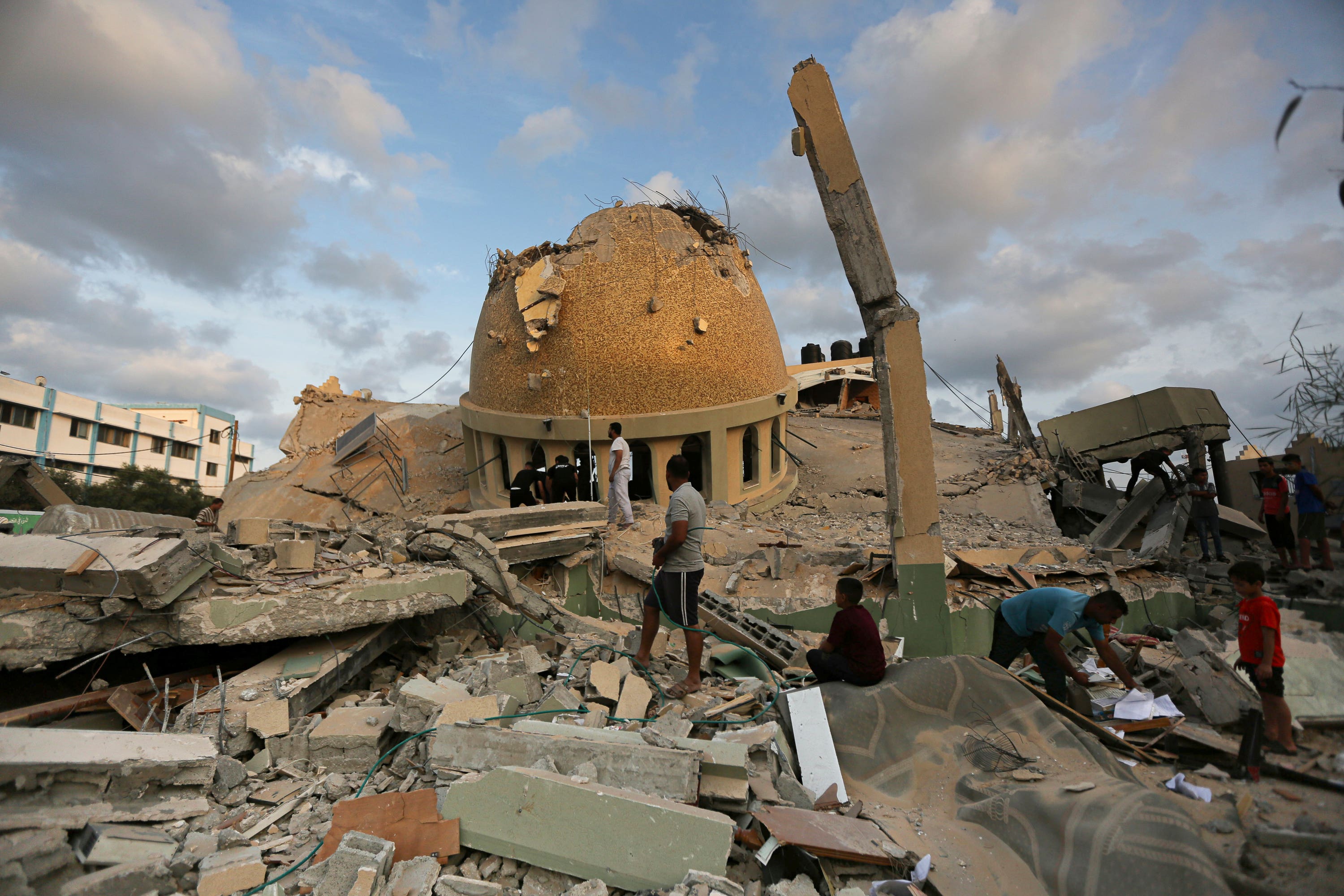 People stand outside a mosque destroyed in an Israeli air strike in Khan Younis, Gaza Strip.