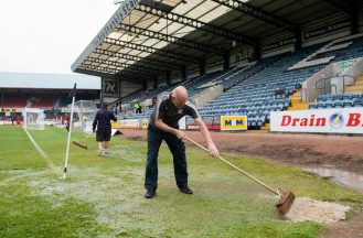 DUNDEE, SCOTLAND - AUGUST 05: Dundee grounds staff sweep water off the pitch before a cinch Premiership match between Dundee and Motherwell at Dens Park, on August 05, 2023, in Dundee, Scotland. (Photo by Sammy Turner / SNS Group)