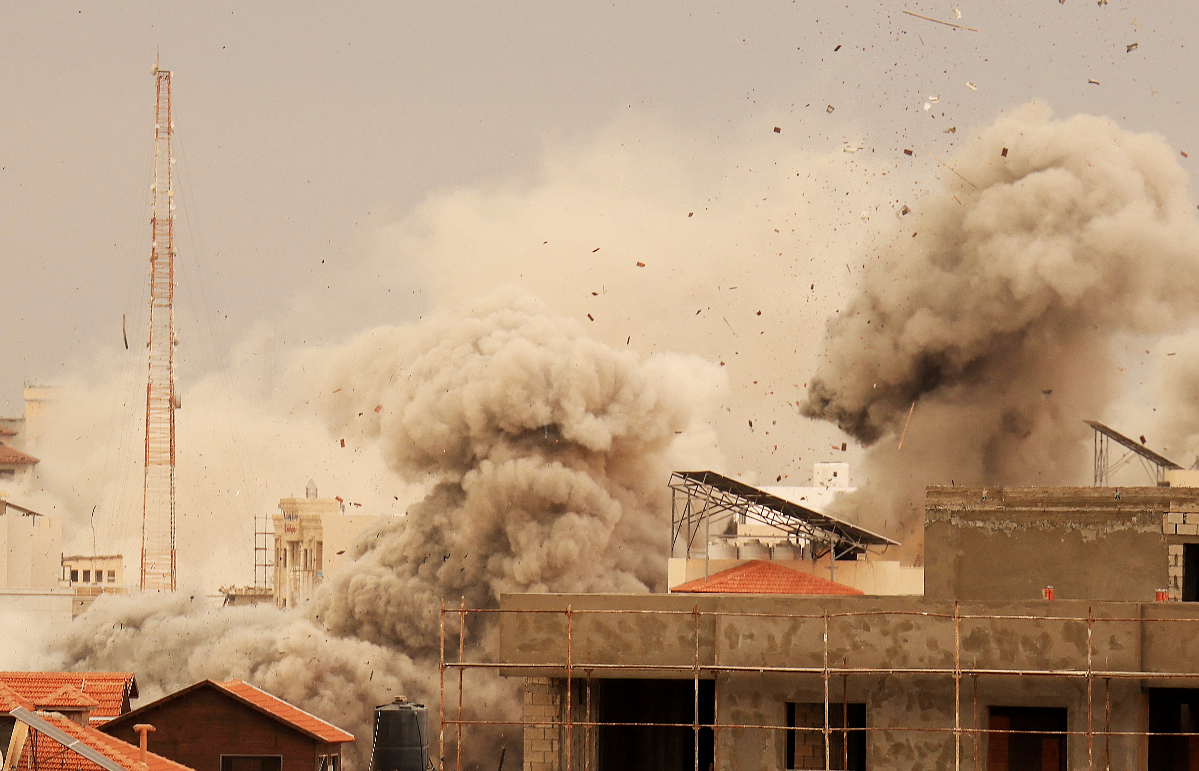 Smoke billows as debris flies in the air during an Israeli airstrike on Gaza City on October 9.