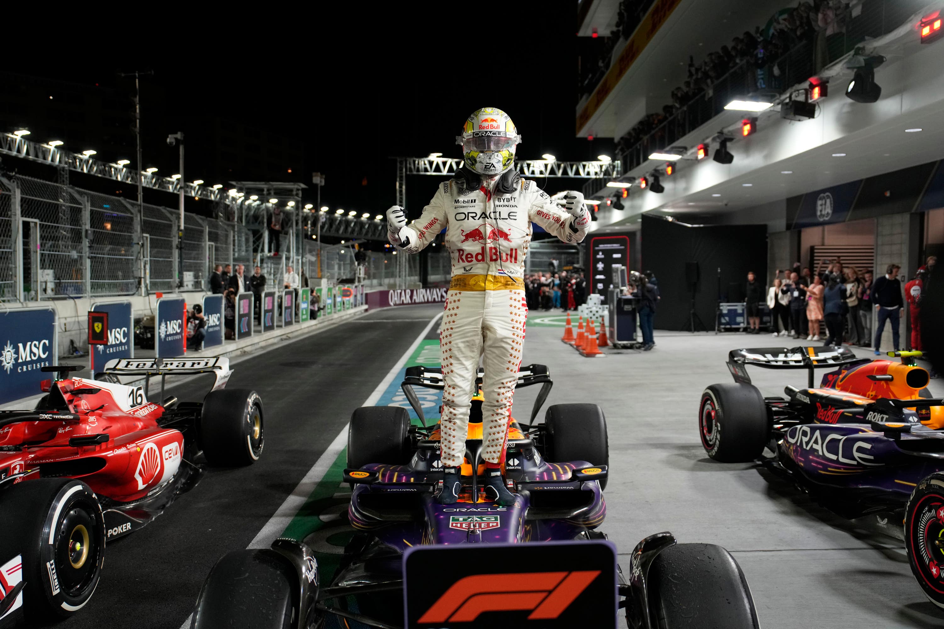 Red Bull driver Max Verstappen stands on top of his car after winning the Formula One Las Vegas Grand Prix.