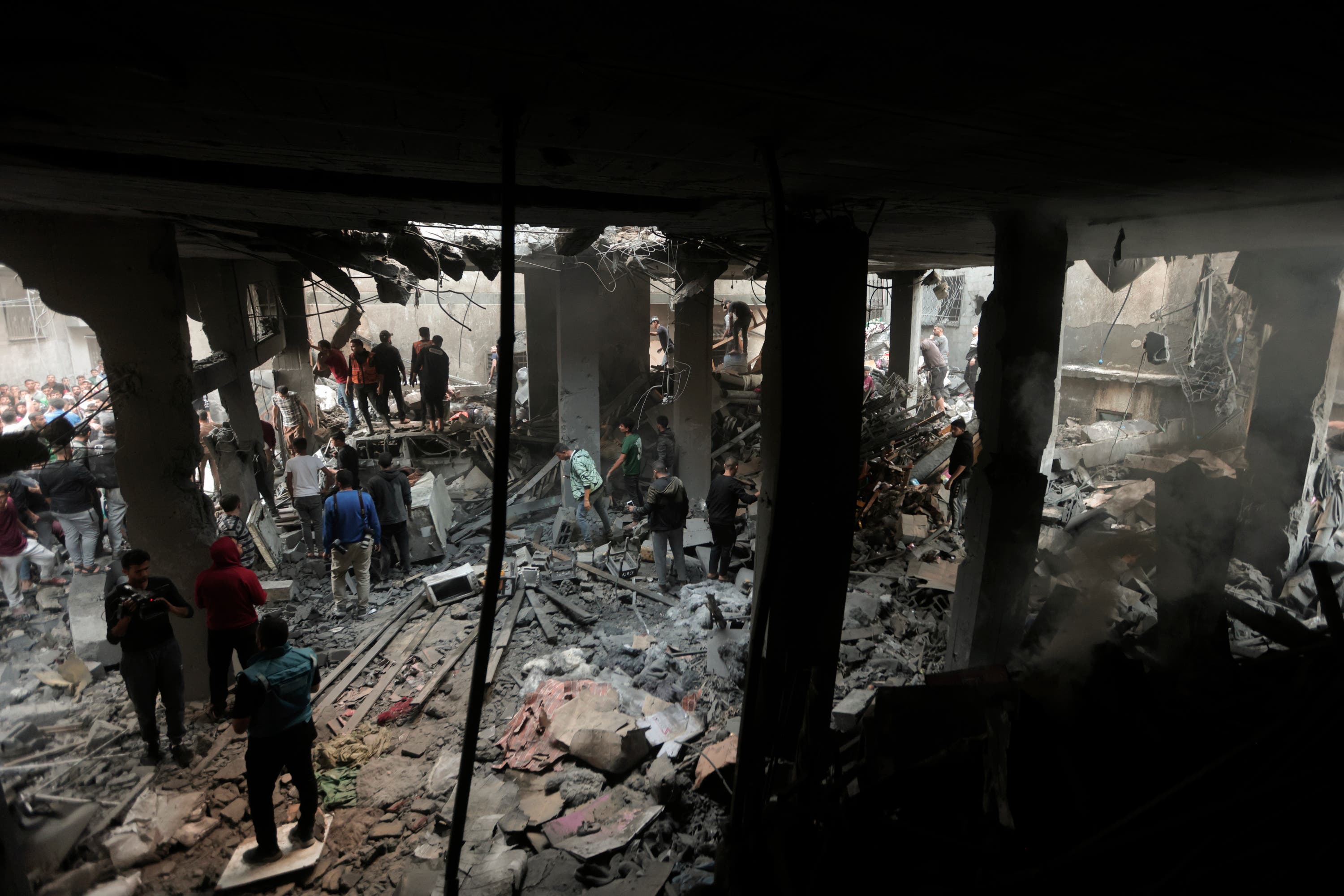 Palestinians look for survivors inside the remains of a destroyed building following an Israeli airstrike in Khan Younis refugee camp, southern Gaza Strip in November 2023