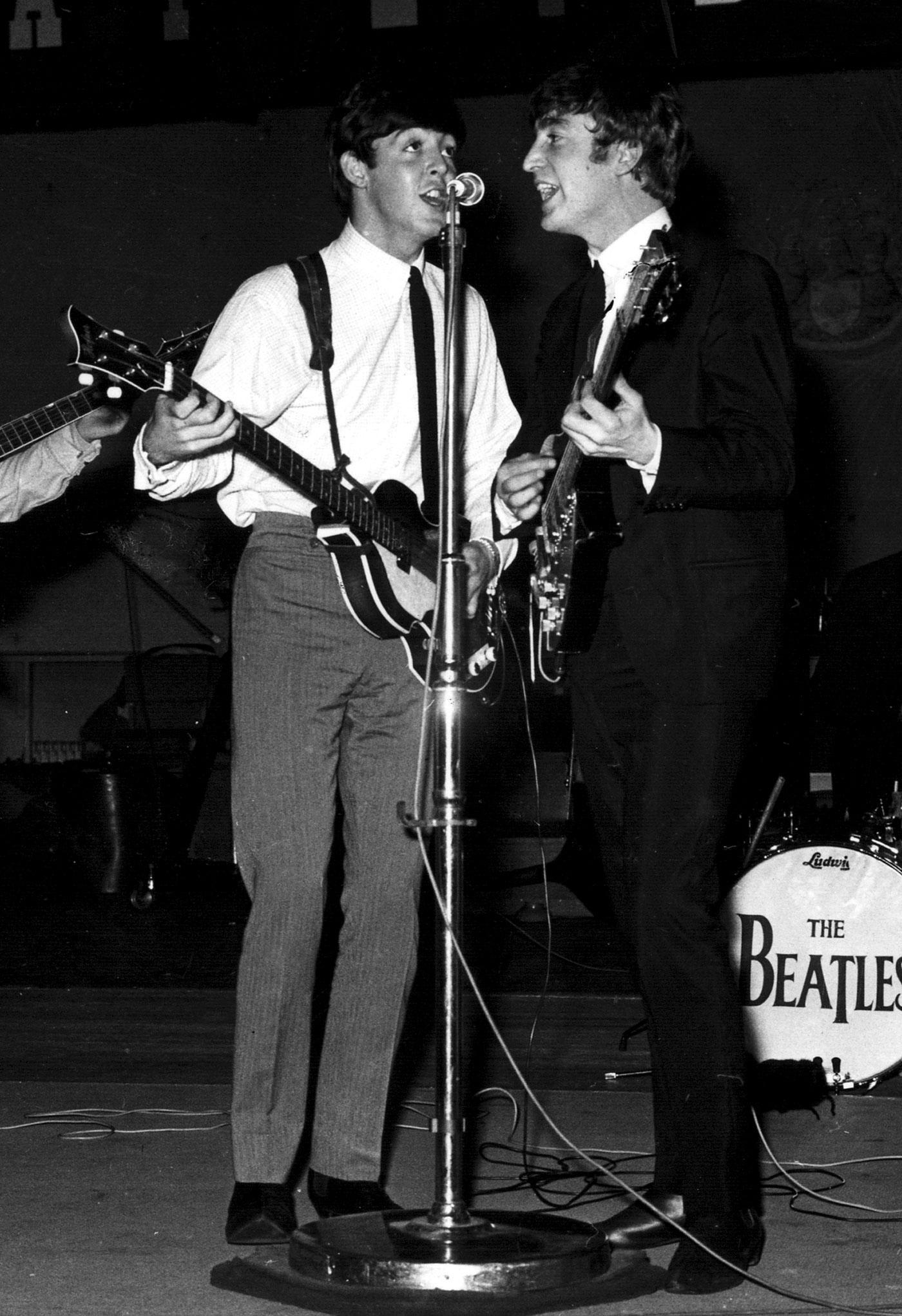 Paul McCartney and John Lennon performing in 1963, the year of The Beatles’ first number one single From Me To You.