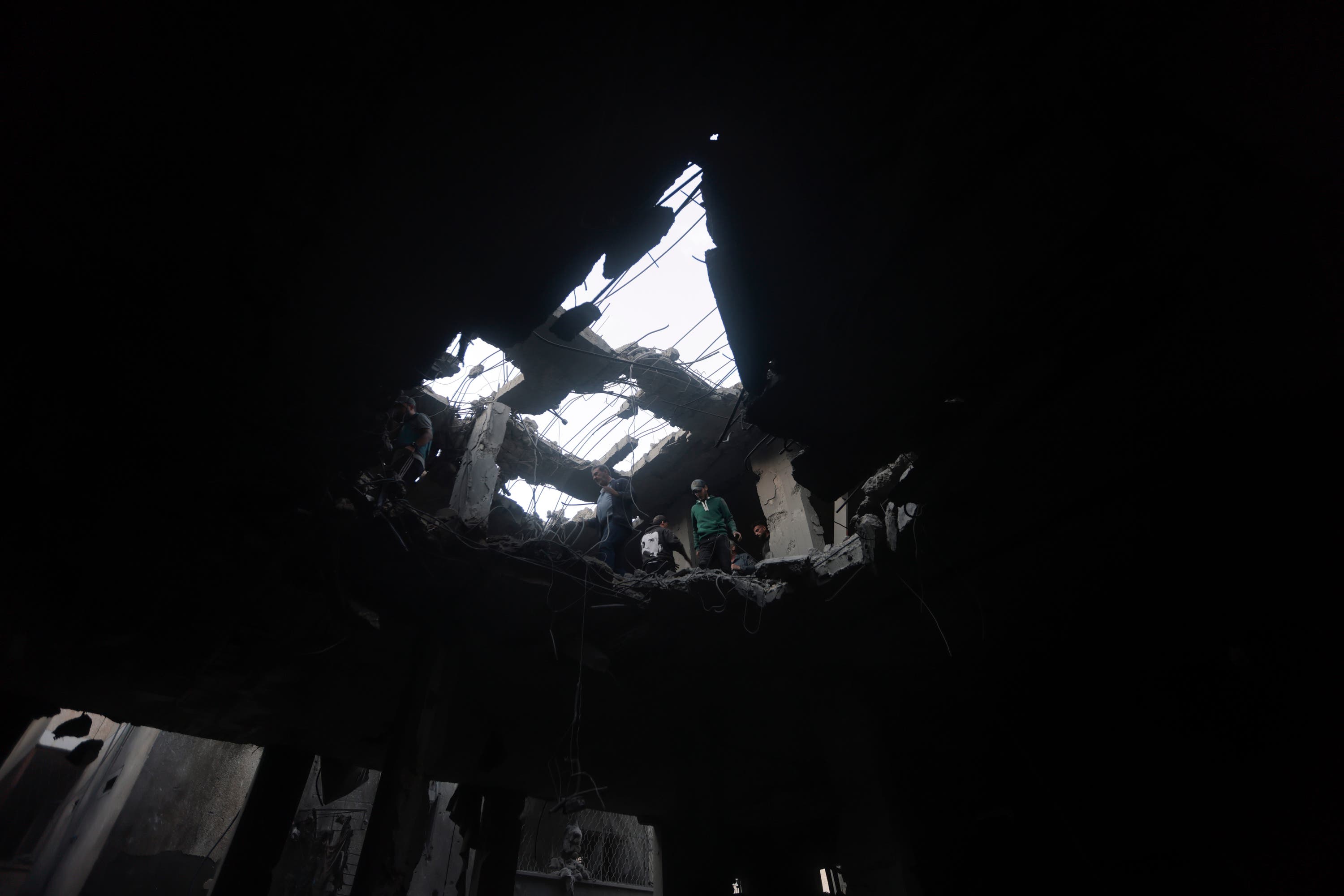 Palestinians look for survivors inside the remains of a destroyed building.