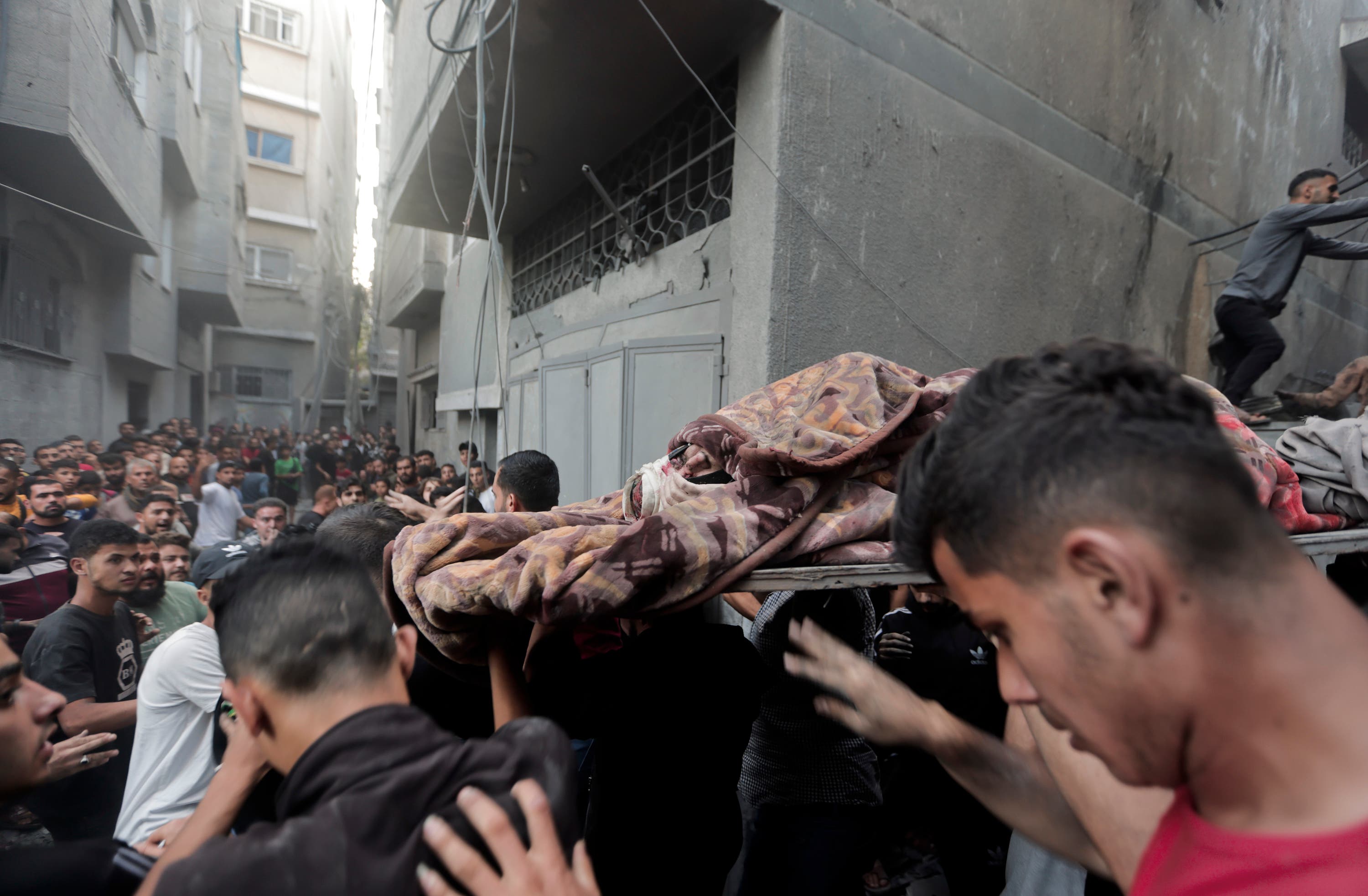 Palestinians evacuate an injured woman found under the rubble of a destroyed house after an Israeli airstrike in Khan Younis refugee camp, southern Gaza Strip, on Saturday.