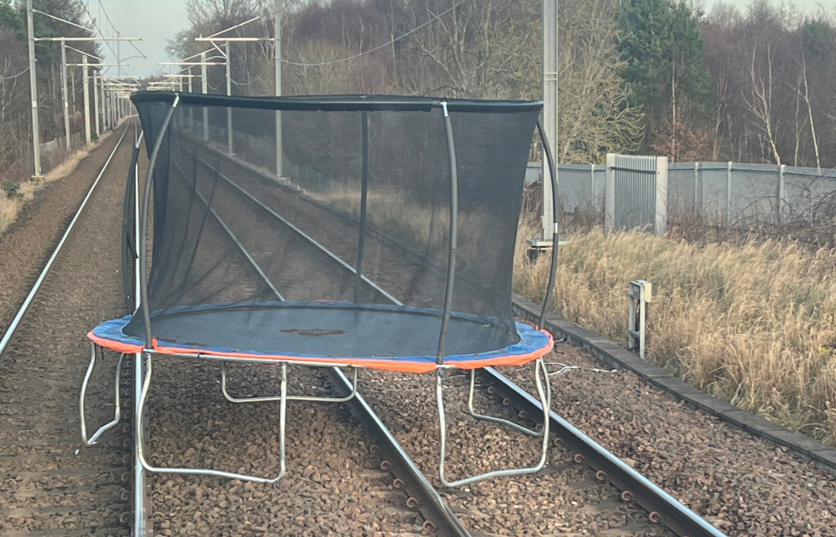 Trains were subjected to delays near Edinburgh after a trampoline was blown onto the tracks.