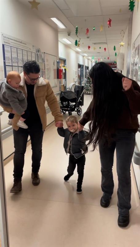 Elijah walked out of hospital holding his parents' hands