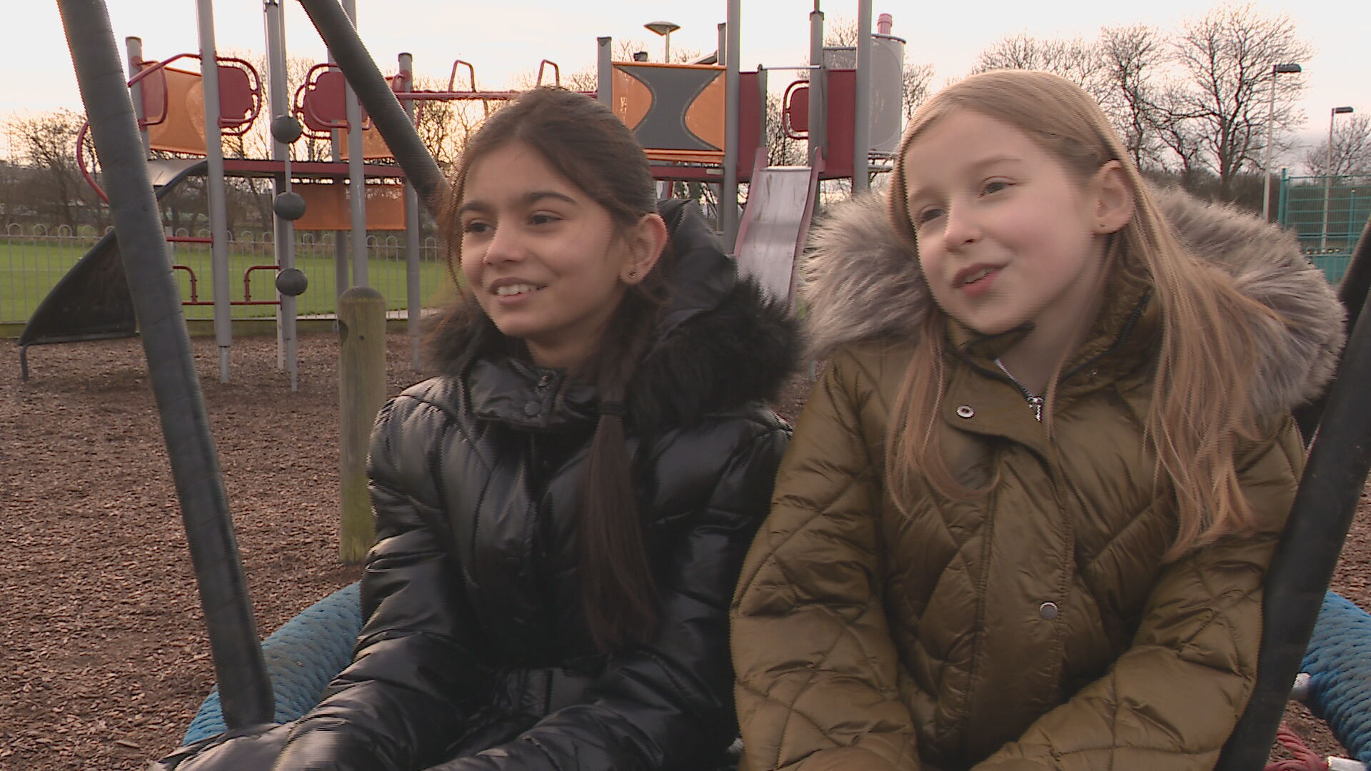 Pupils Aarvi and Zuza on the basket swing in their local park they campaigned to get back after it was vandalised. 