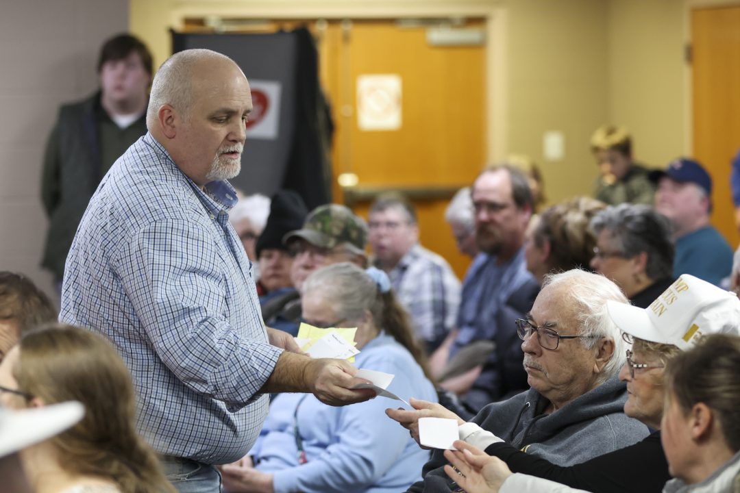 Michael Hilton collects caucus ballots at East Side Christian Church in Council Bluffs, Iowa.