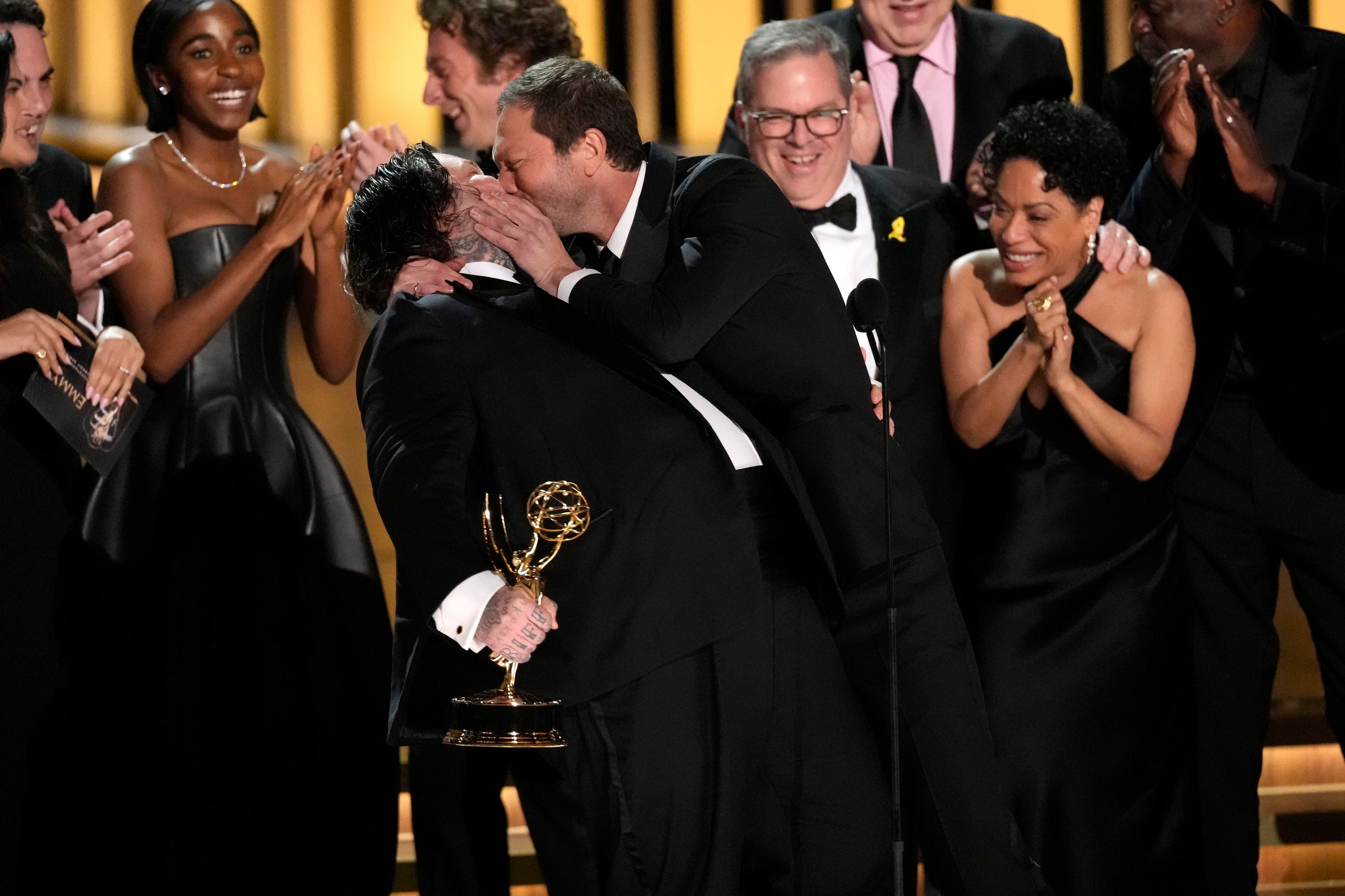 Matty Matheson, centre, and Ebon Moss-Bachrach kiss as The Bear wins the award for outstanding comedy series during the 75th Primetime Emmy Awards.