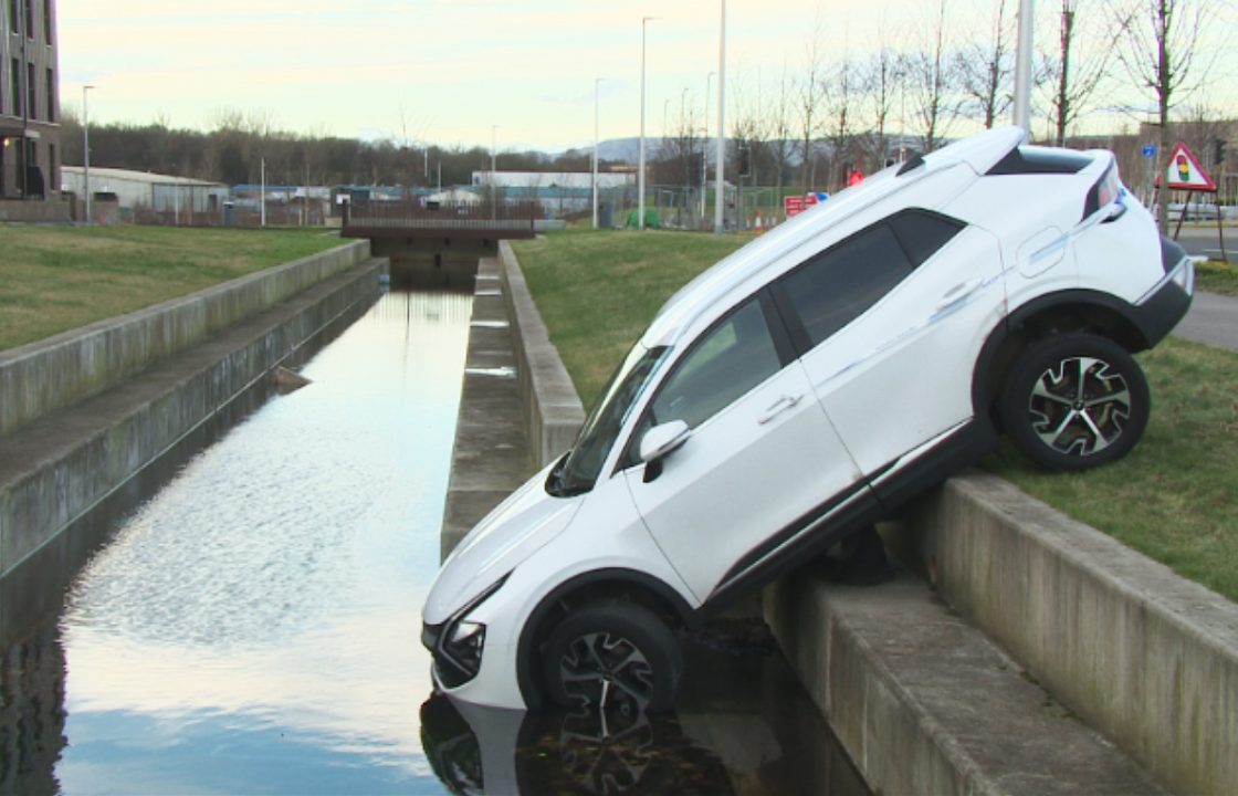 Car balances precariously after careering into Glasgow canal
