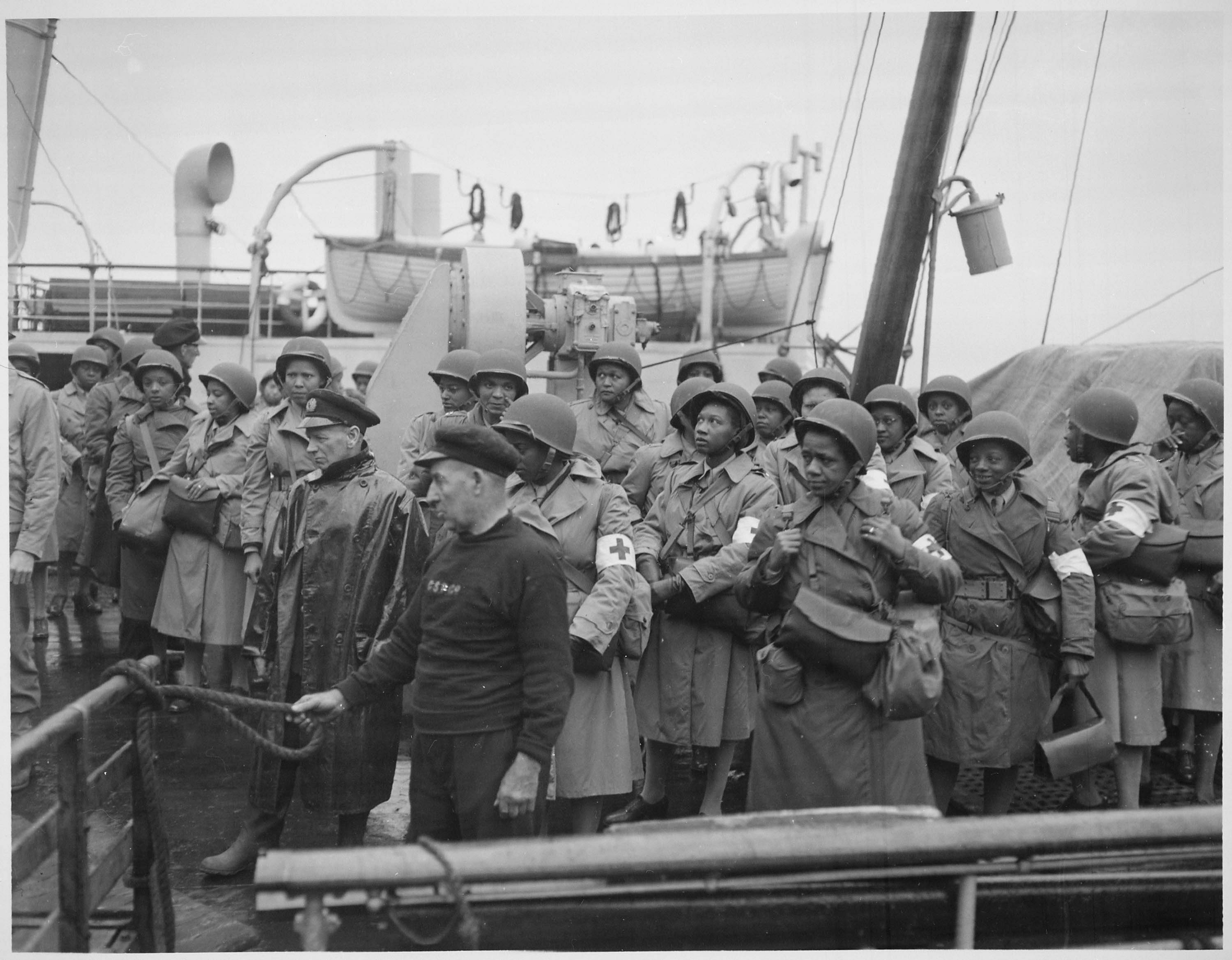 US Army nurses, newly arrived, line the rail of their vessel as it pulls into port of Greenock, Scotland, in European Theatre of Operations during World War 2, 1944. Image courtesy National Archives. (Photo by Smith Collection/Gado/Getty Images).