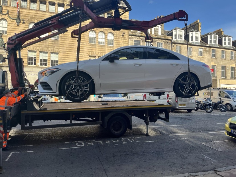 A car with a blue badge being displayed fraudulently being lifted for impoundment on George Street