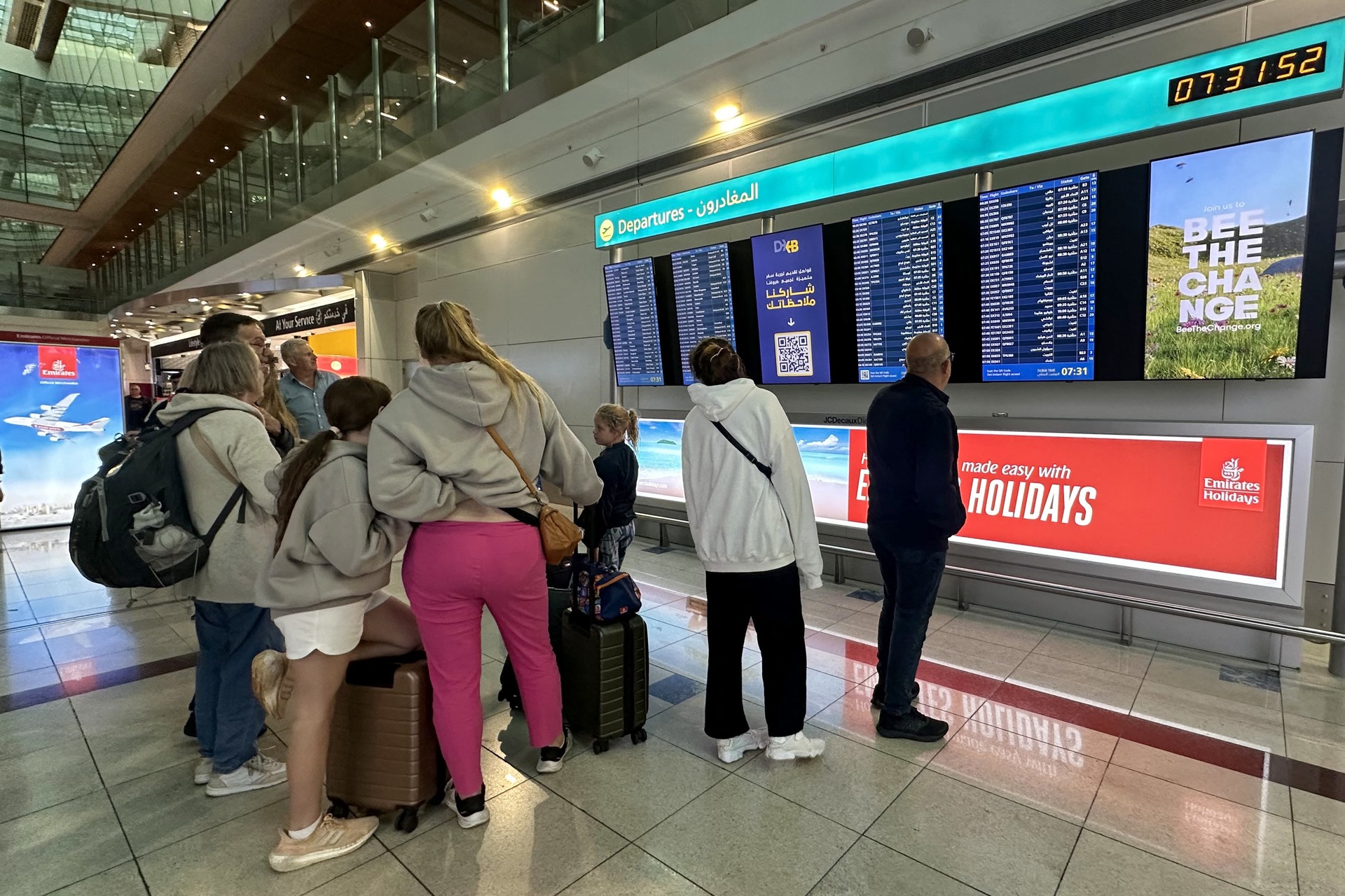 Passengers check flight information on screens at the Dubai International Airport in Dubai on April 17, 2024.