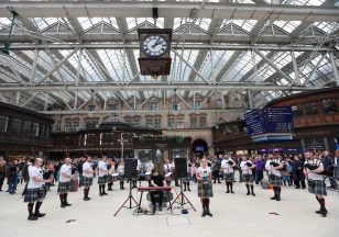 Pipe band brings Scotland’s busiest train station to a standstill with live performance