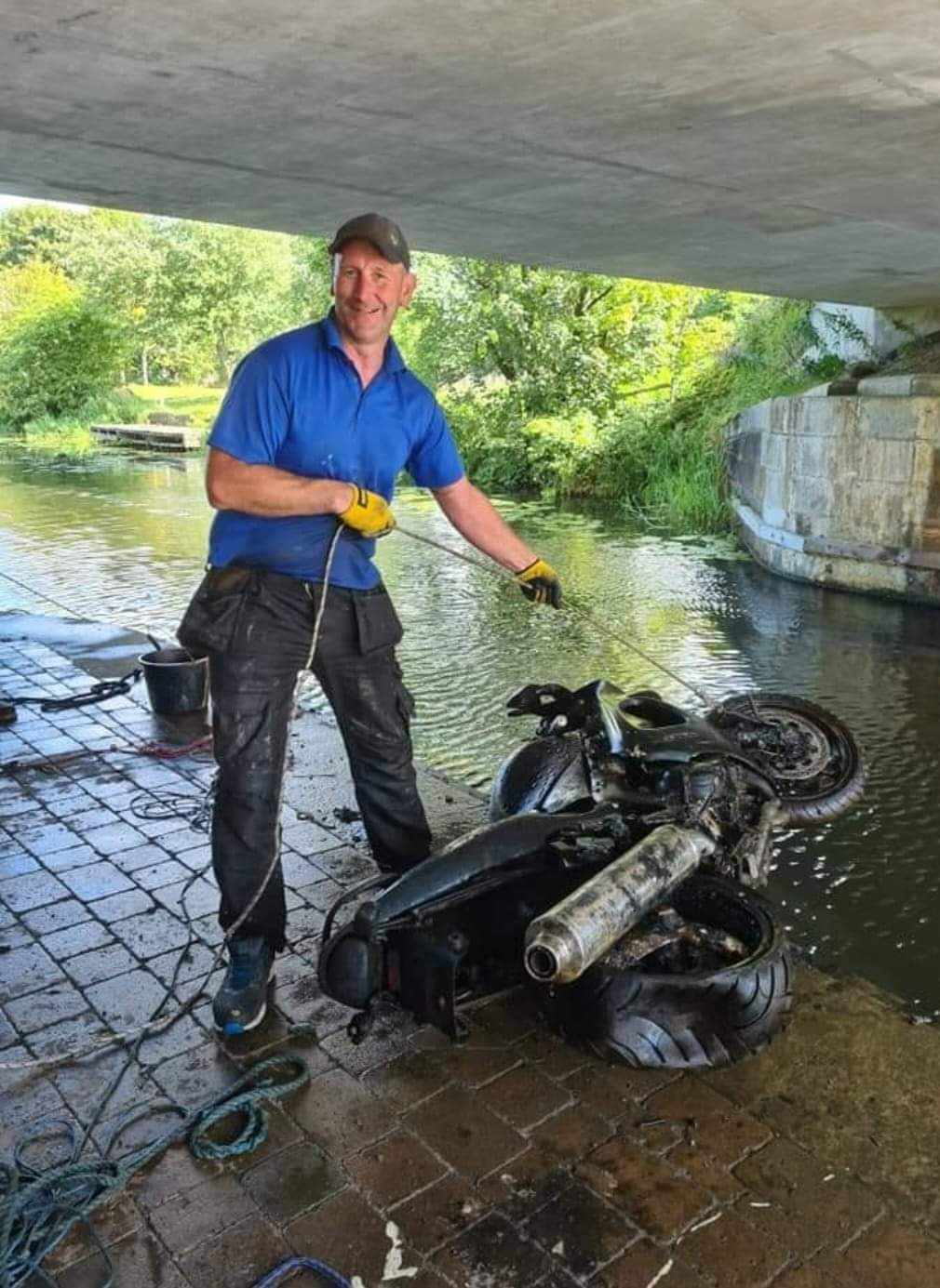 Glasgow Magnet Fishing, group admin Paul Goody with a motorbike pulled up from a canal. 