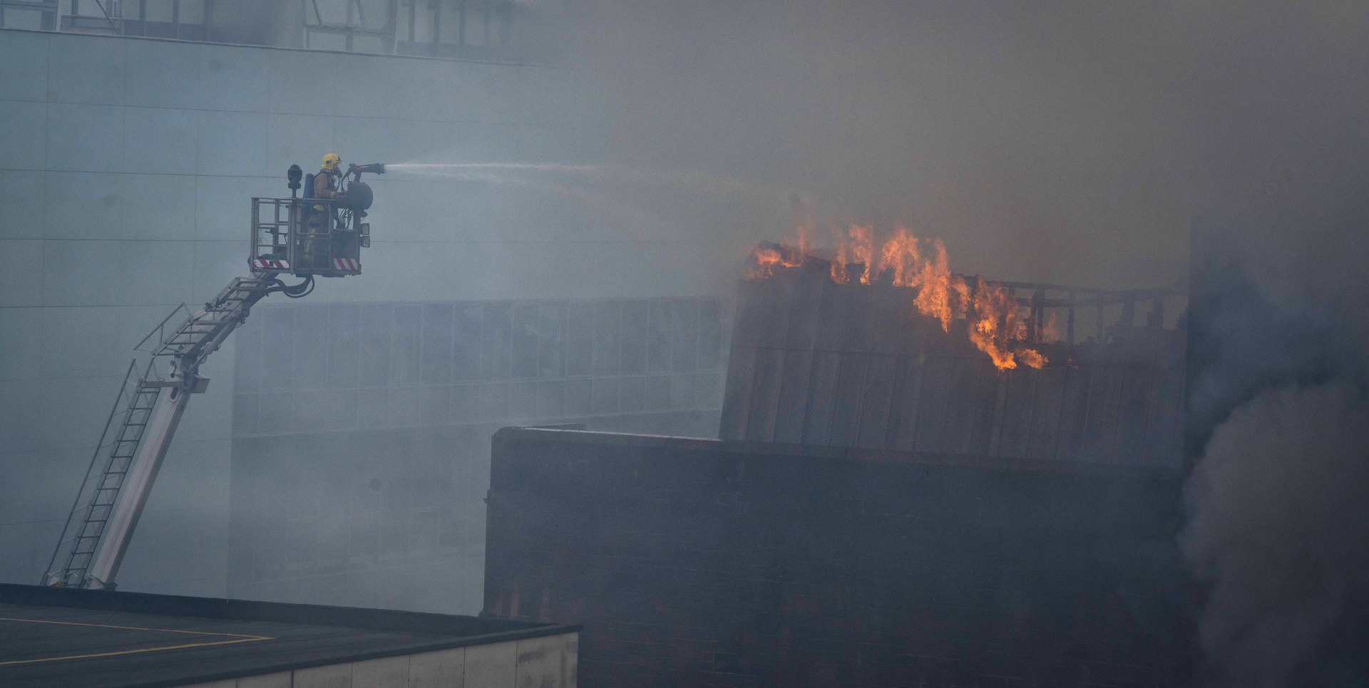 A firefighter works to put out a fire at the Glasgow School of Art Charles Rennie Mackintosh Building on May 23, 2014.