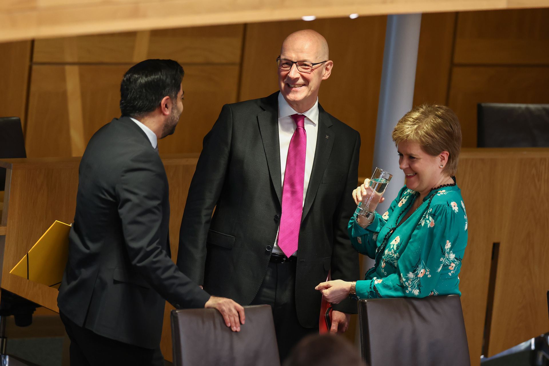 Humza Yousaf and John Swinney and Nicola Sturgeon react after he delivered his farewell speech as First Minister at the Scottish Parliament.
