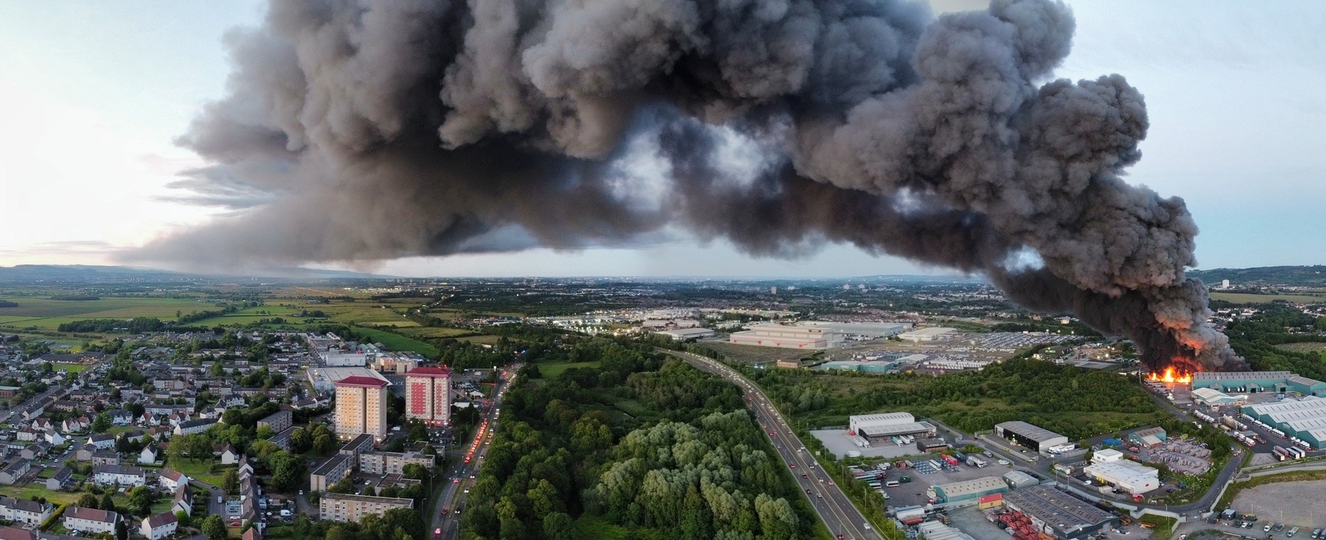 A massive plume of smoke has engulfed the sky west of Glasgow after a fire erupted near an industrial estate in Paisley.