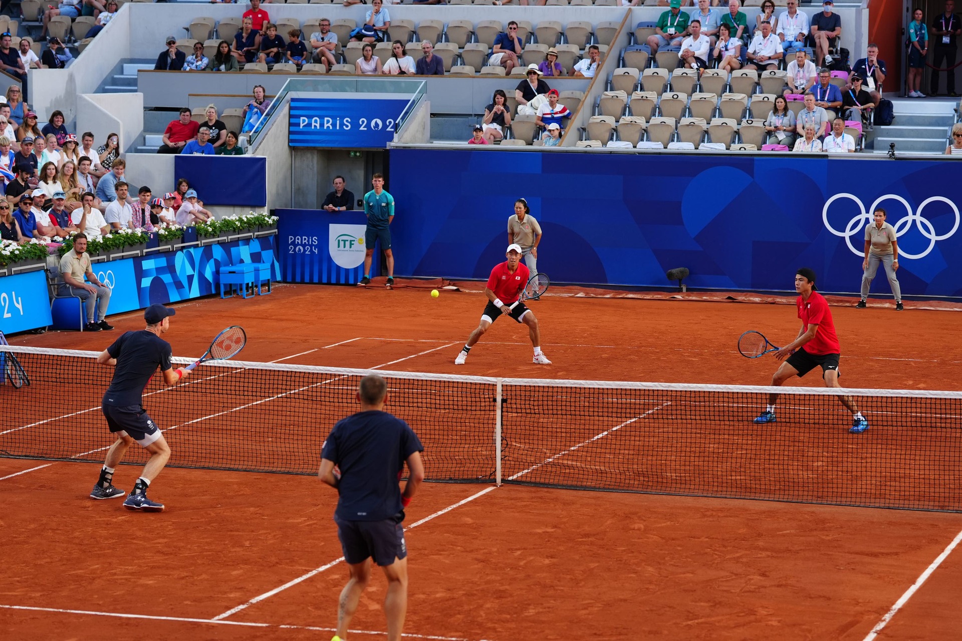 Andy Murray, left, hits a volley in the doubles match with his partner Dan Evans (Peter Byrne/PA) 