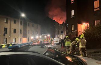 Firefighters tackle blaze at Dundee tenement block as flames shoot through roof